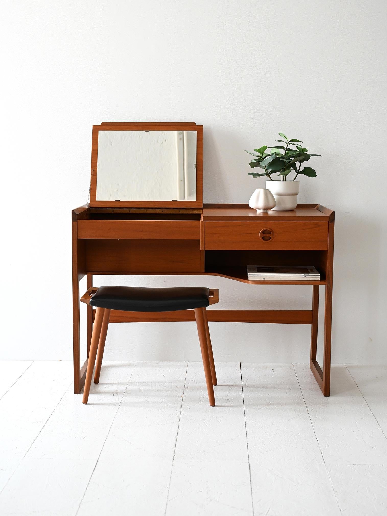 Toeletta con specchio a ribalta, cassettino laterale, mensola e struttura con finitura a doppio tono.

Profilo leggero e geometrico per questa toeletta scandinava anni ’60, realizzata in teak con elegante finitura a doppio colore. Il piano integra