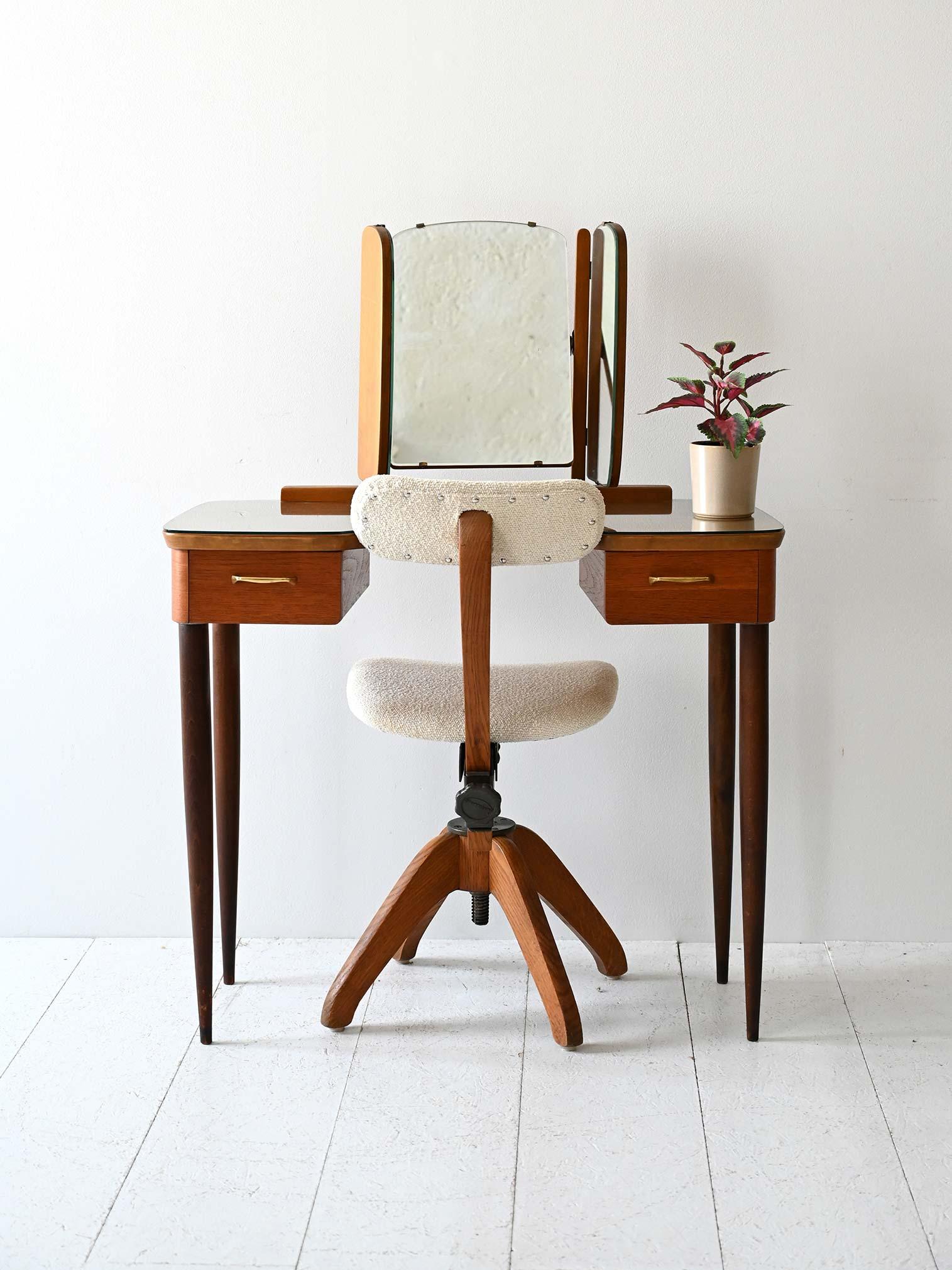 Mid-century wooden dressing table with opening mirror.

Vintage Scandinavian dressing table from the 1950s/60s with wooden frame and central hinged mirror that can be opened on both sides. Slim top, tapered legs, and two drawers with brass handles.