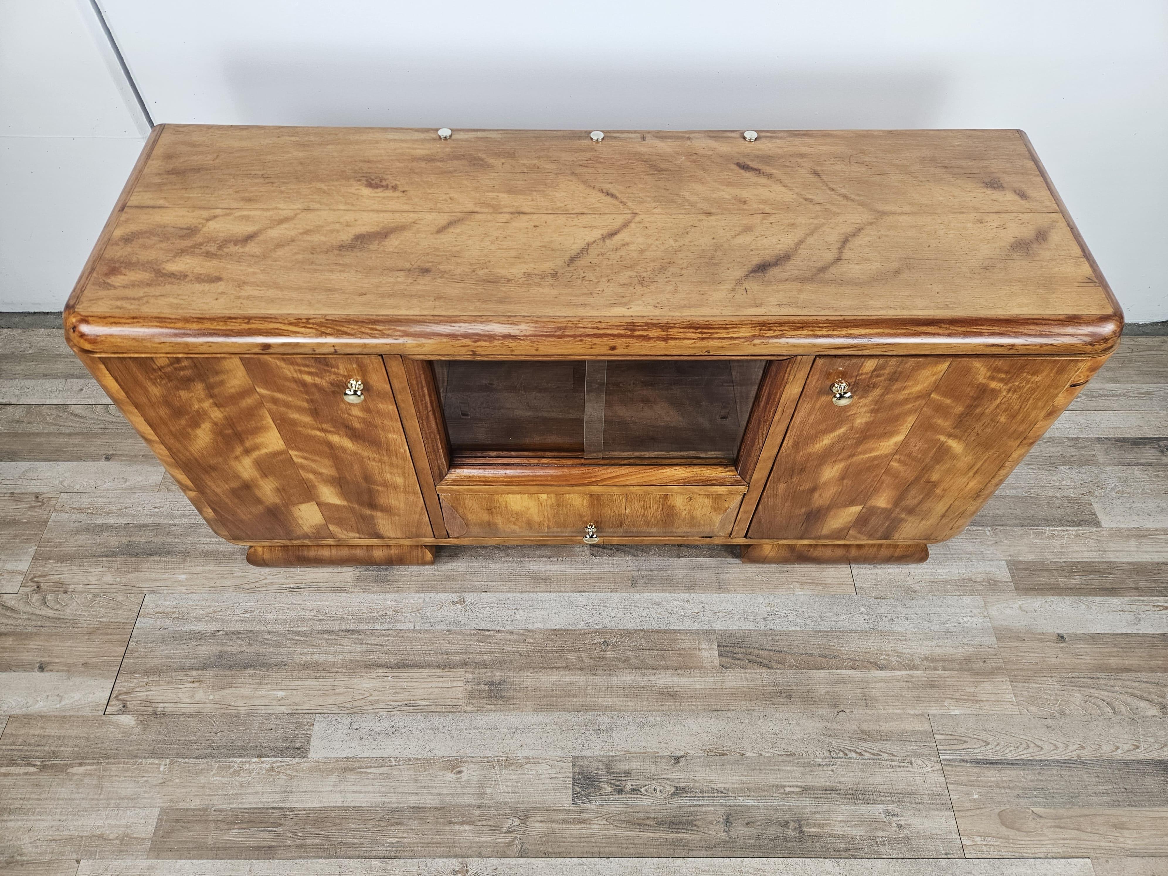 Elegant 1940s dressing table covered in blond walnut burl with double side doors and interior shelves.
In the center is an original period sliding glass with compartment and a large, solid drawer at the base.

Very distinctive and restrained in