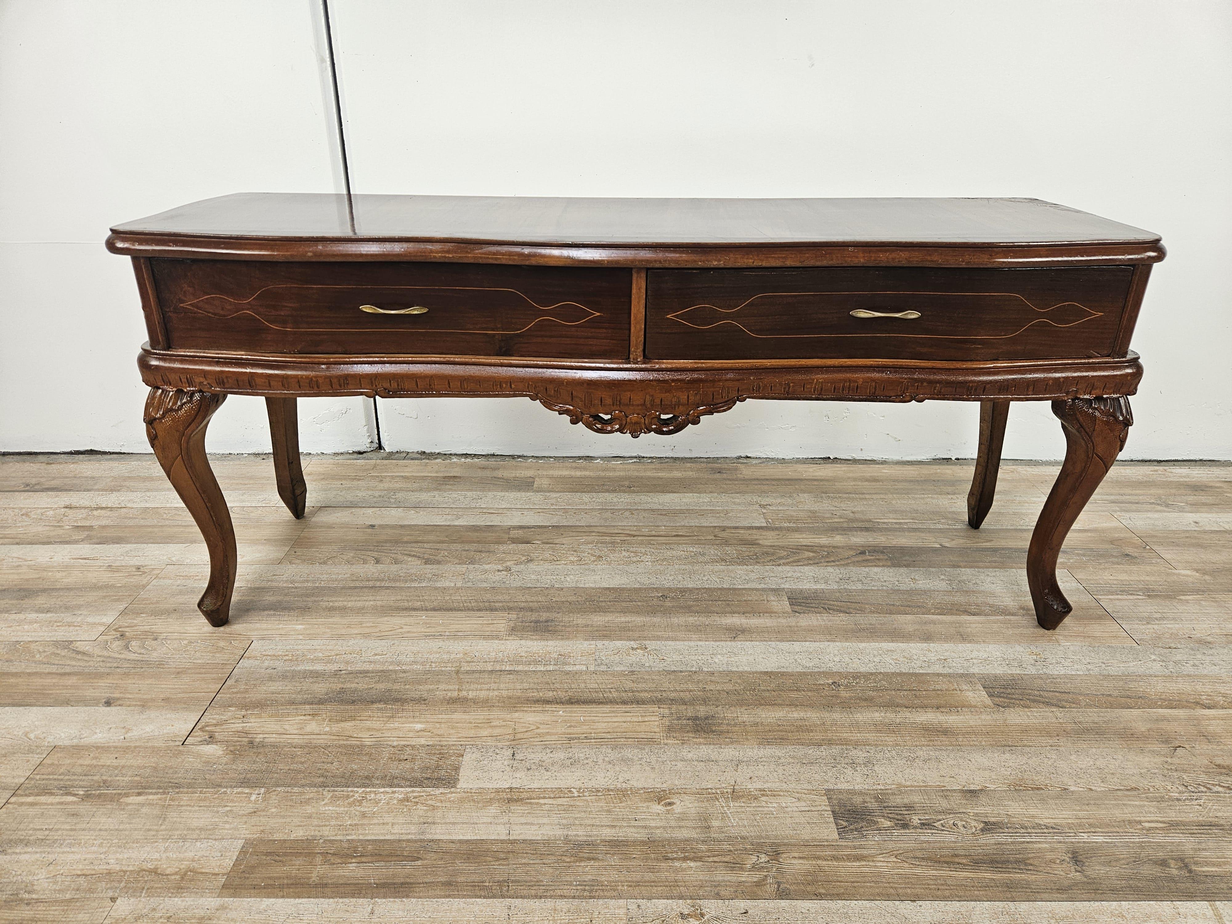 Toilette de style Chippendale des années 1930 en noyer avec double tiroir et poignées en laiton.

Le meuble présente des décorations sculptées et travaillées, les pieds et la ligne douce et sobre sont également remarquables, ce qui permet à la