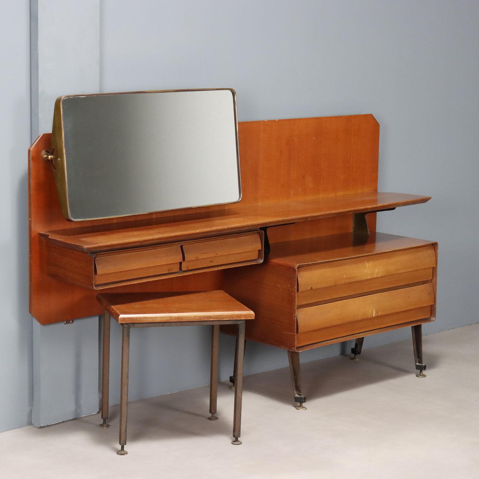 Arredo da stanza composto da toelette mobili in legno impiallacciato mogano con specchio basculante con cornice in ottone, quattro cassetti di cui due grandi e due più piccoli, gambe in metallo smaltato nero con puntali in ottone e sgabellino con