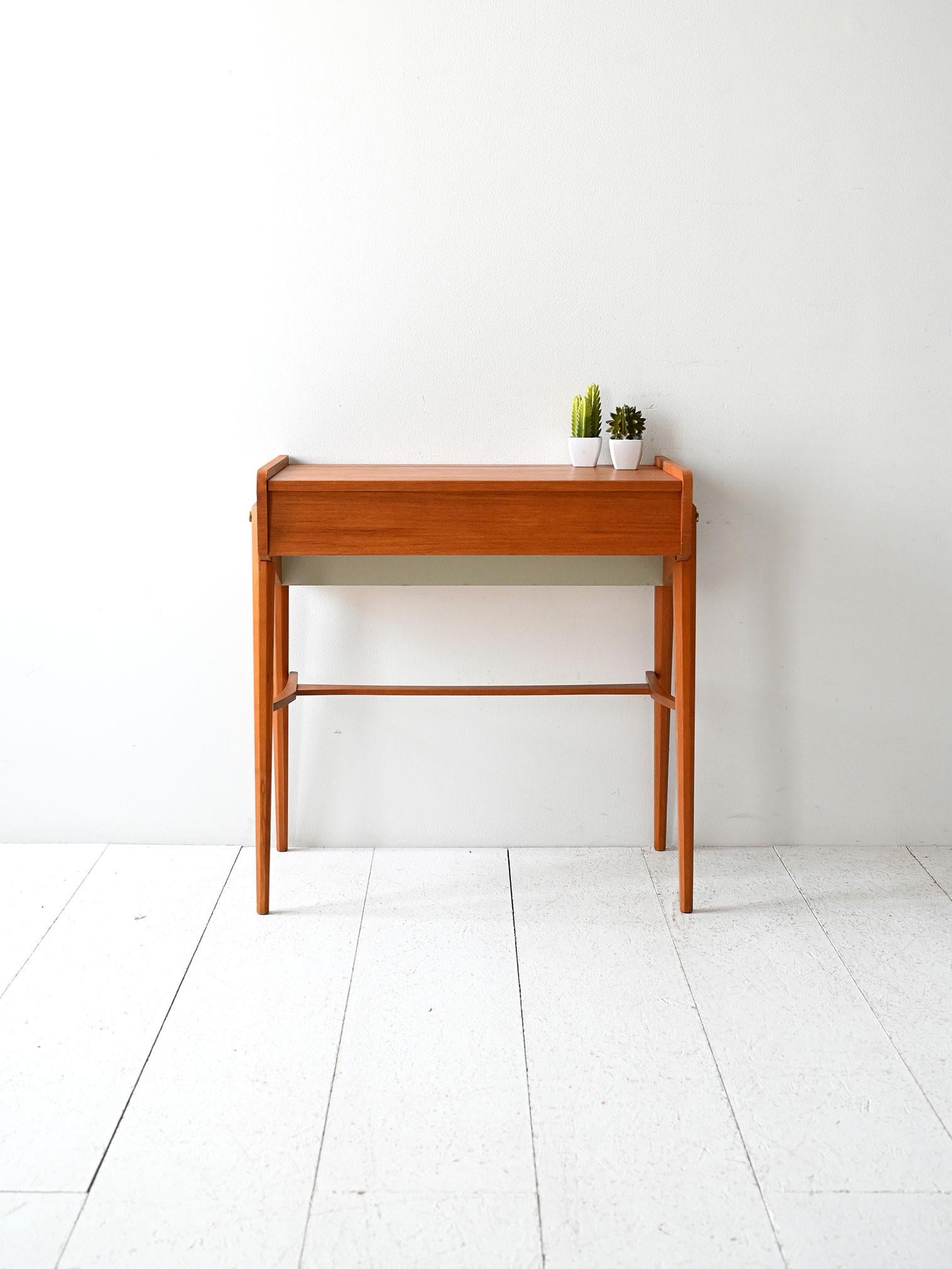 Toelette anni ’60 in teak con ribalta, specchio integrato e vano contenitore. Linee geometriche e struttura leggera.

Toelette vintage scandinava con apertura a ribalta e specchio integrato, realizzata in teak con finitura calda e uniforme. Il vano