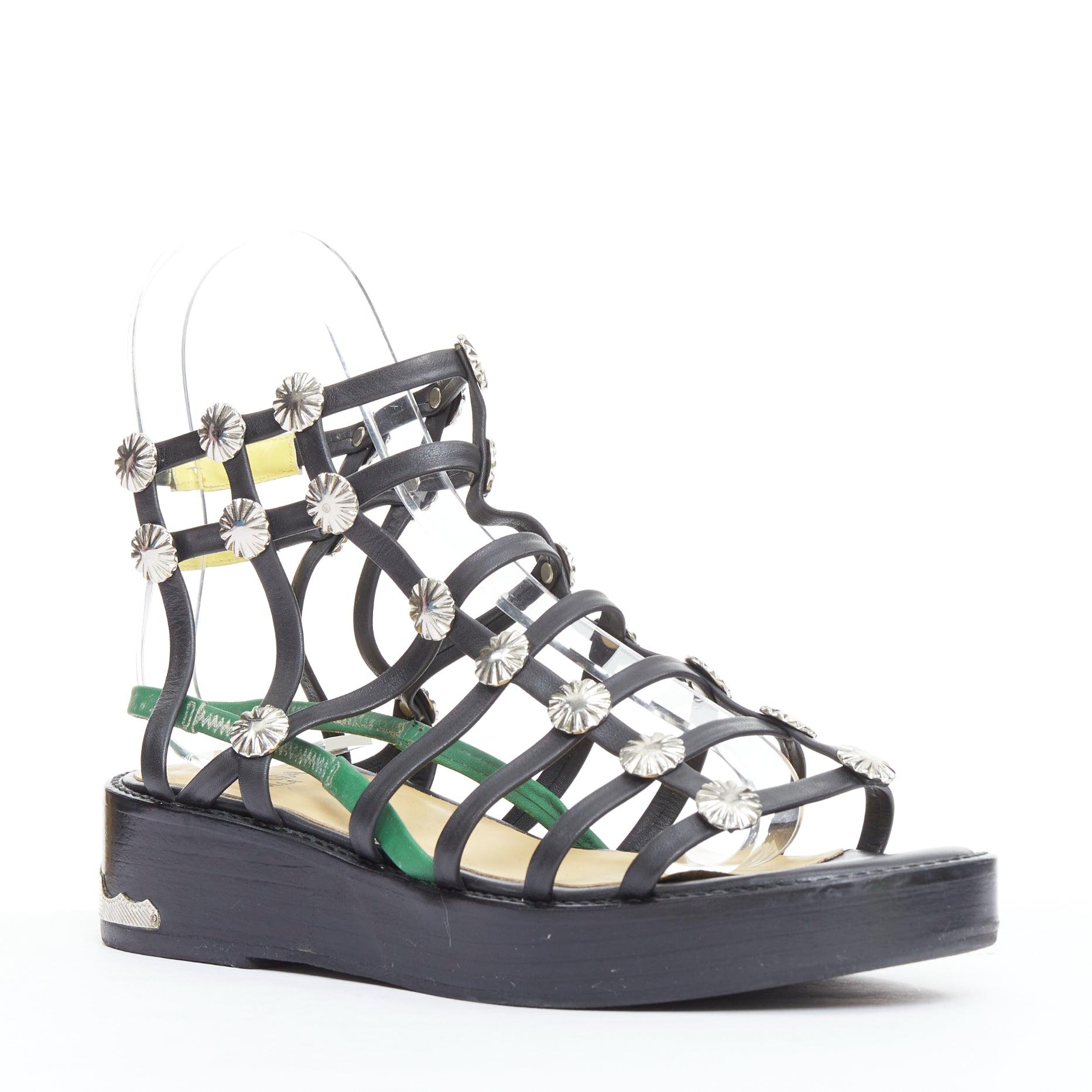 TOGA ARCHIVES PULLA black caged silver stud platform gladiator sandals
Reference: NILI/A00101
Brand: Toga Archives
Collection: Pulla
Material: Leather, Metal
Color: Black, Green
Pattern: Solid
Closure: Button
Lining: Nude Leather
Extra Details: