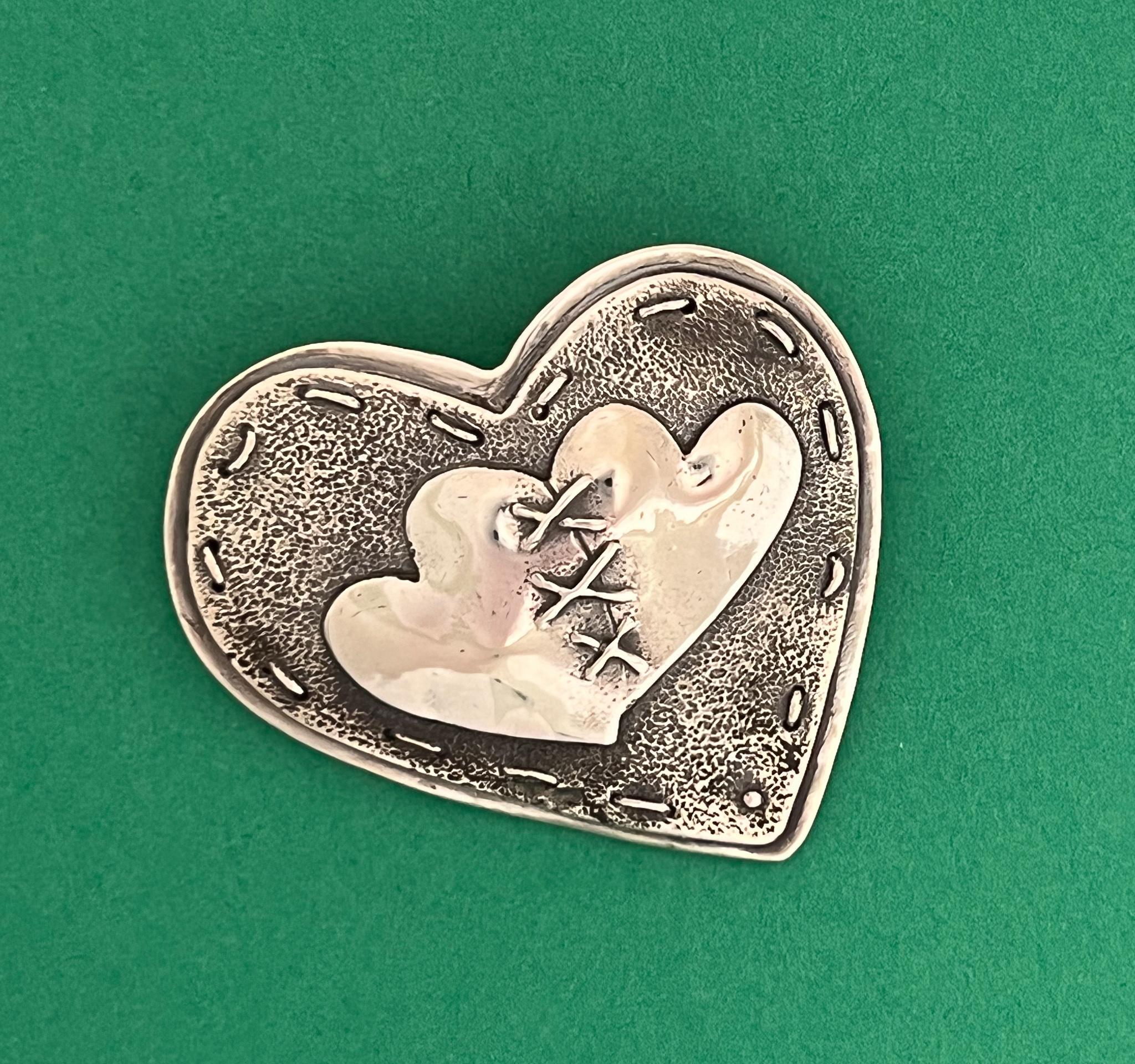 Together  Three Hearts, by Kerr Green, sterling silver, pin, pendant, stitched,contempoary

Artist jewelry line from Santa Fe, New Mexico. Can be worn as a pin or pendant. Layered, stitched cast silver. 
Art ready to wear.