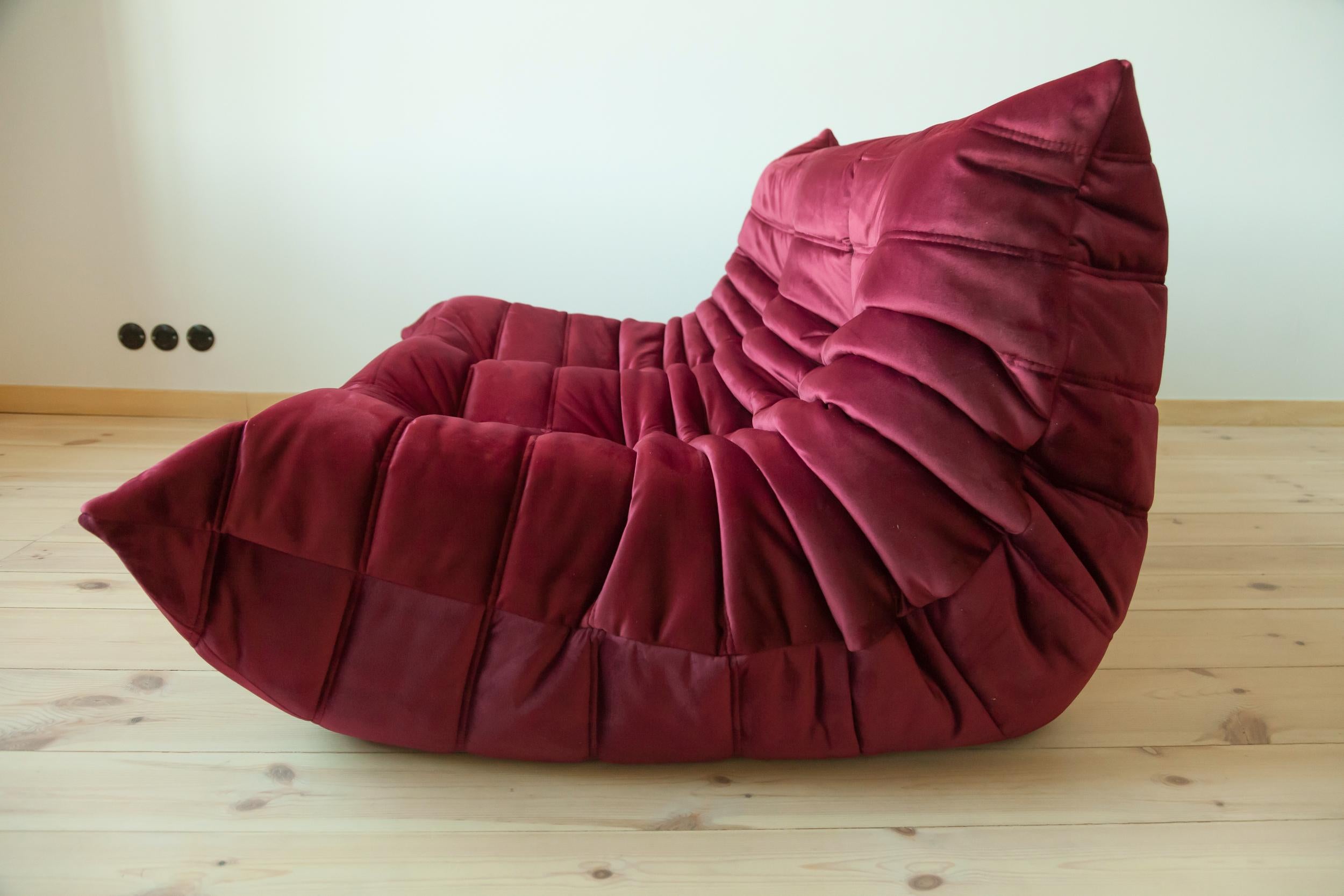 This two-seat Togo couch was designed by Michel Ducaroy in 1973 and was manufactured by Ligne Roset in France. It has been reupholstered in new burgundy velvet (131 x 102 x 70 cm). It has the original Ligne Roset logo and genuine Ligne Roset bottom.