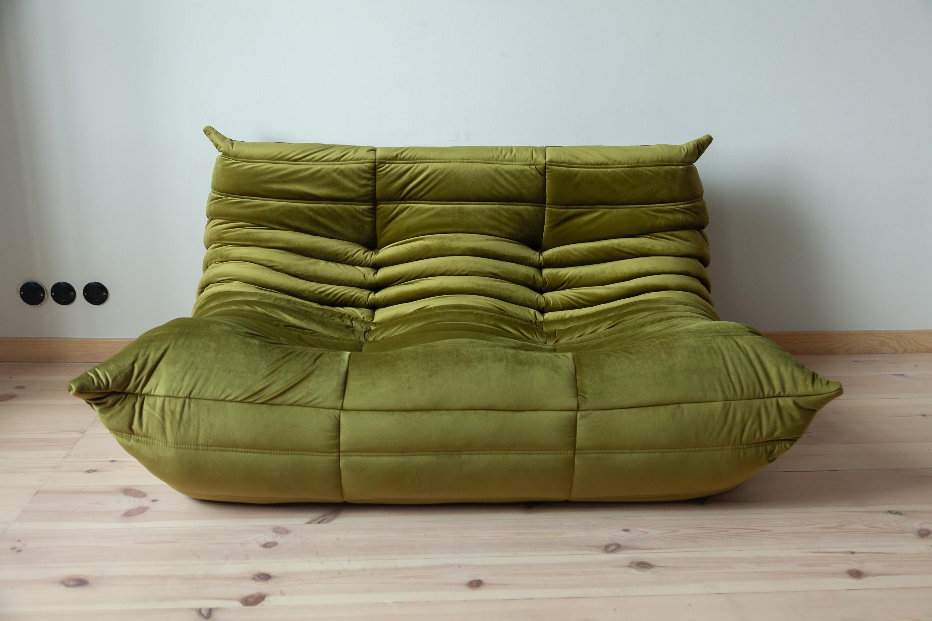 This two-seat Togo couch was designed by Michel Ducaroy in 1973 and was manufactured by Ligne Roset in France. It has been reupholstered in new olive green velvet (131 x 102 x 70 cm). It has the original Ligne Roset logo and genuine Ligne Roset
