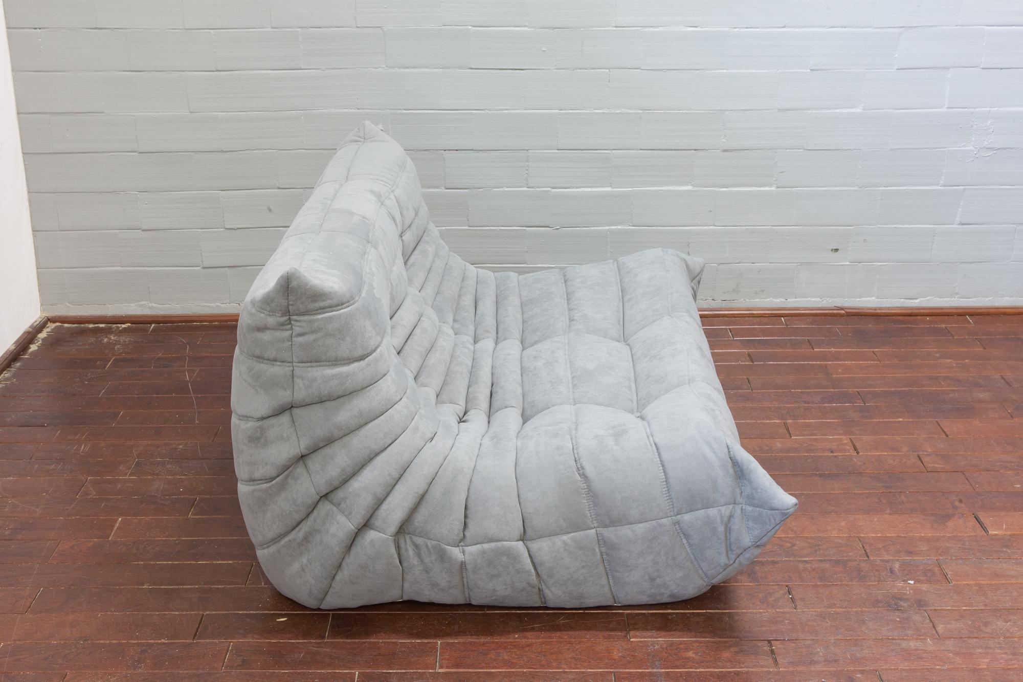 This Togo two-seat couch was designed by Michel Ducaroy in 1973 and was manufactured by Ligne Roset in France. It has been reupholstered in new light grey microfibre (131 x 102 x 70 cm). It has the original Ligne Roset logo and genuine Ligne Roset