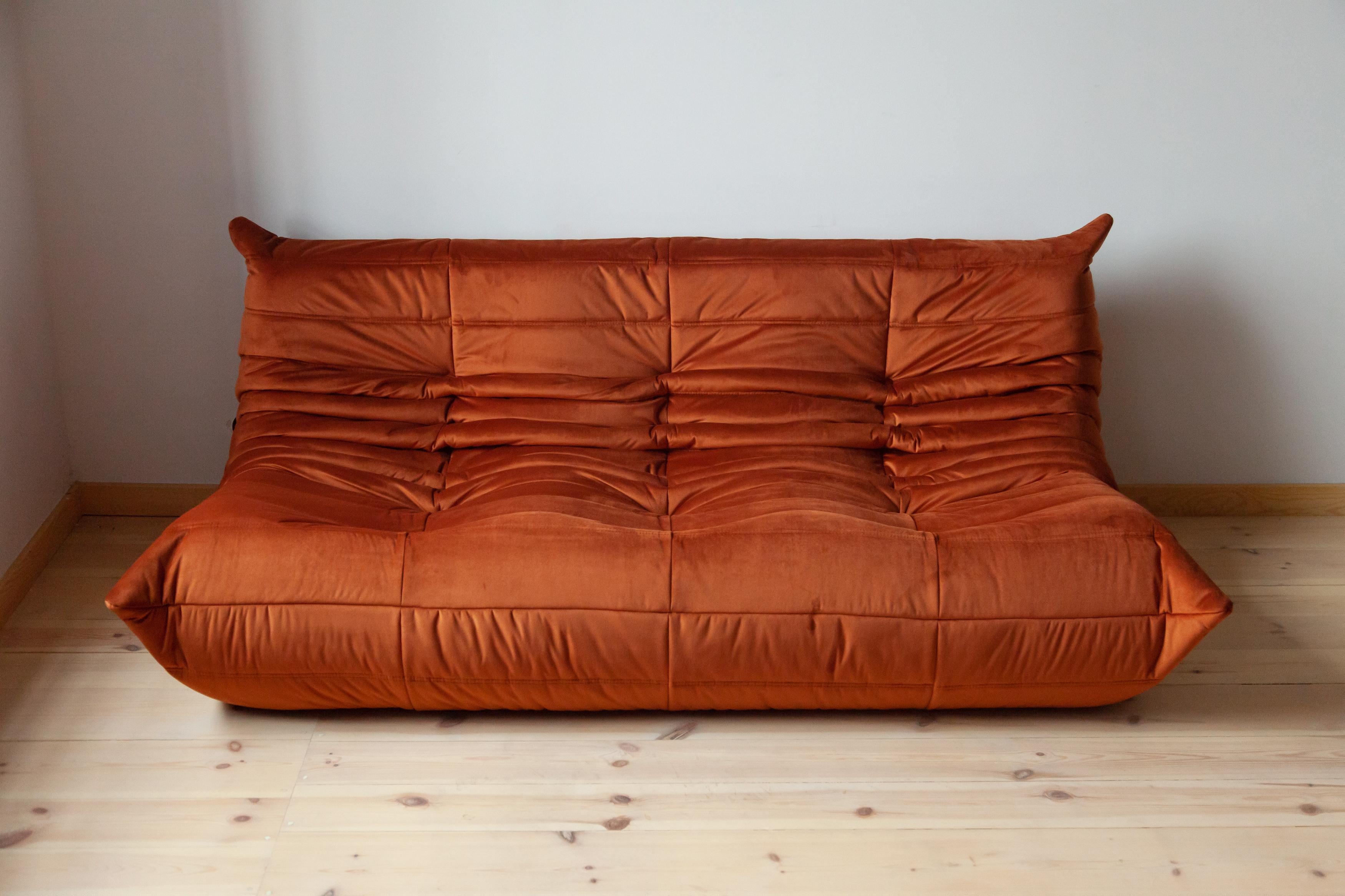 This Togo three-seat sofa was designed by Michel Ducaroy in 1973 and was manufactured by Ligne Roset in France. It has been reupholstered in new amber velvet (70 x 174 x 102 cm). It has the original Ligne Roset logo and genuine Ligne Roset bottom.