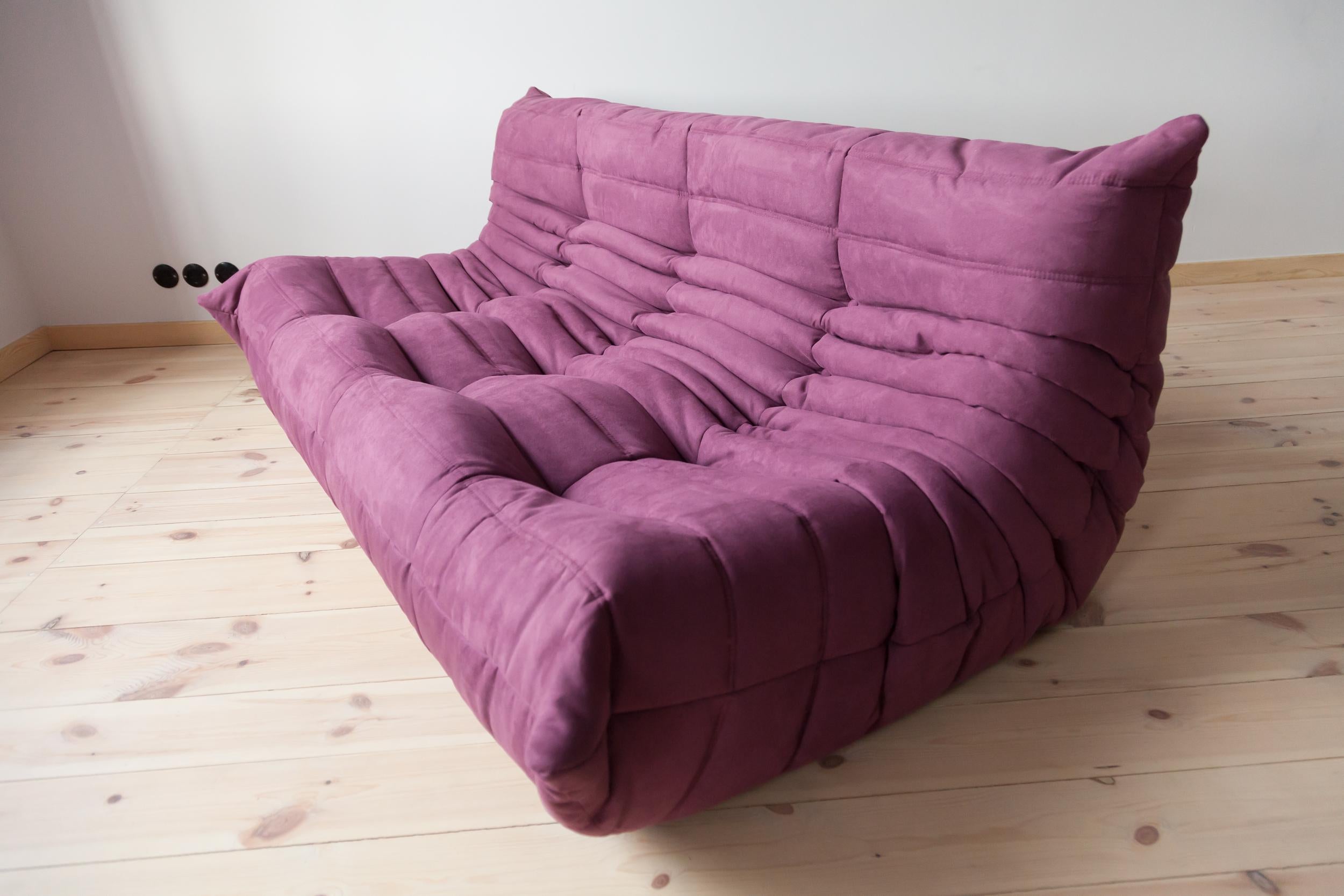 This Togo three-seat sofa was designed by Michel Ducaroy in 1973 and was manufactured by Ligne Roset in France. It has been reupholstered in new aubergine/purple microfibre (70 x 172 x 102 cm). It has the original Ligne Roset logo and genuine Ligne