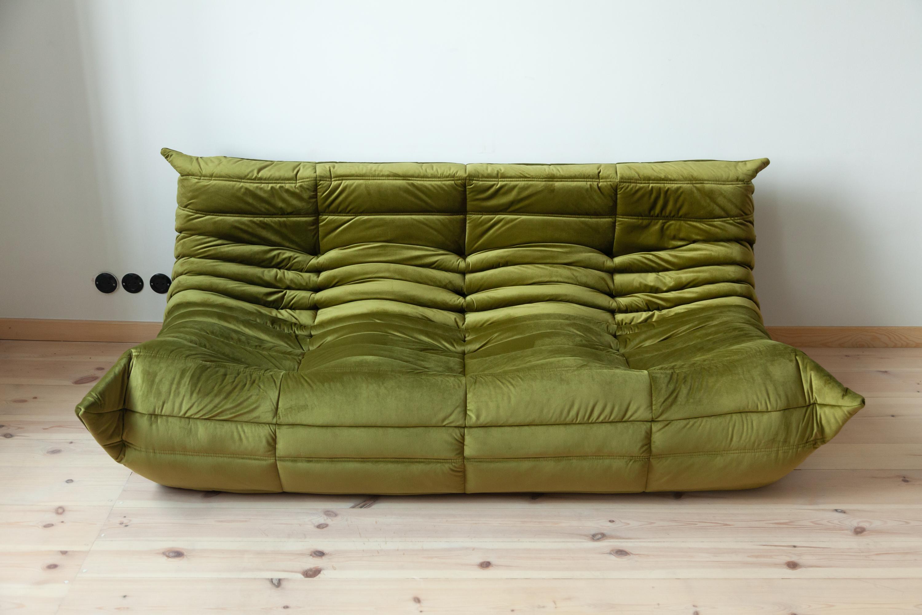 This vintage Togo three-seat sofa was designed by Michel Ducaroy in 1973 and was manufactured by Ligne Roset in France. It has been reupholstered in new olive green velvet (70 x 174 x 102 cm). It has the original Ligne Roset logo and genuine Ligne