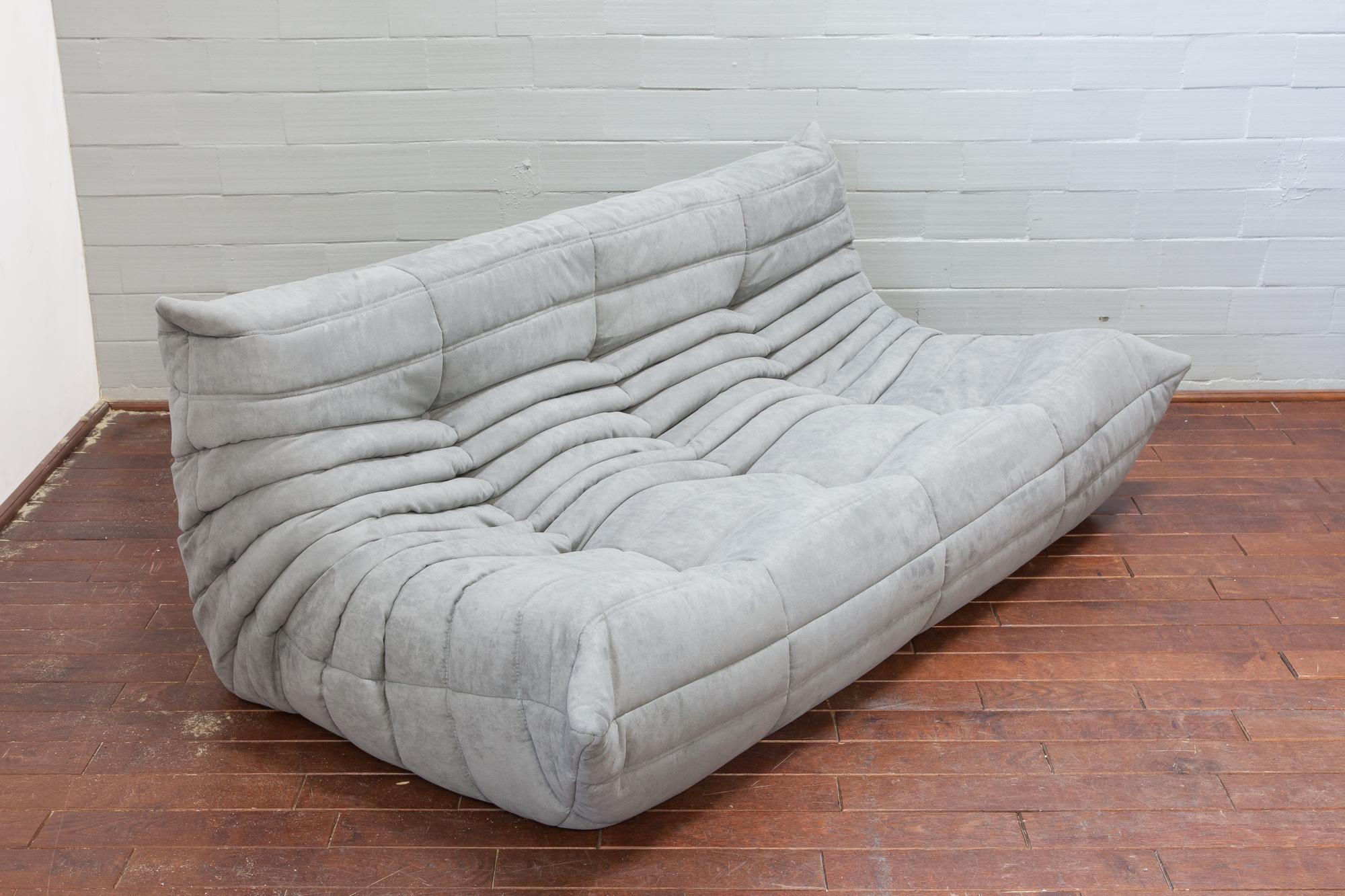 This Togo three-seat sofa was designed by Michel Ducaroy in 1973 and was manufactured by Ligne Roset in France. It has been reupholstered in new light grey microfibre (70 x 174 x 102 cm). It has the original Ligne Roset logo and genuine Ligne Roset