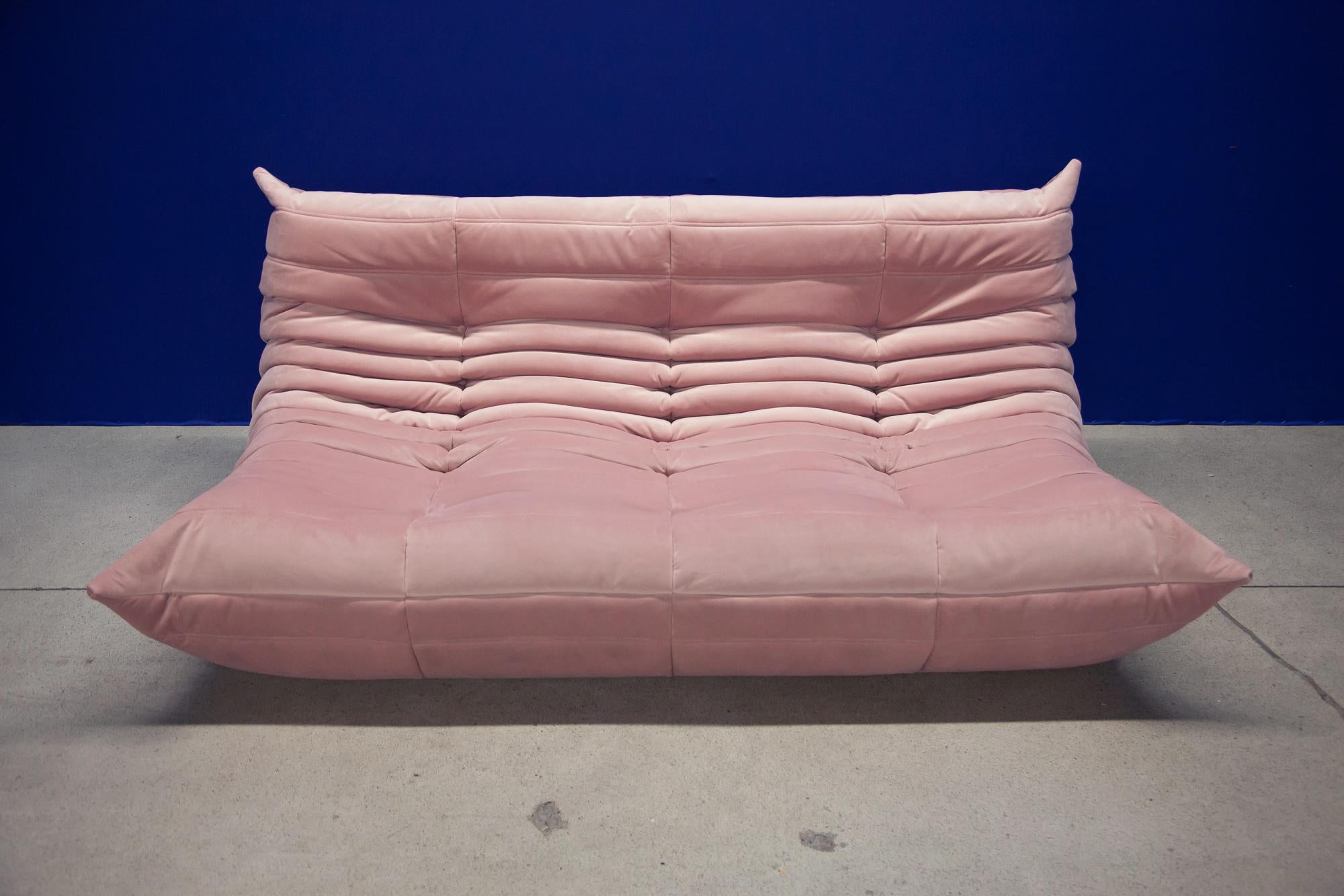 This Togo three-seat sofa was designed by Michel Ducaroy in 1973 and was manufactured by Ligne Roset in France. It has been reupholstered in new pink velvet (70 x 174 x 102 cm). It has the original Ligne Roset logo and genuine Ligne Roset bottom.