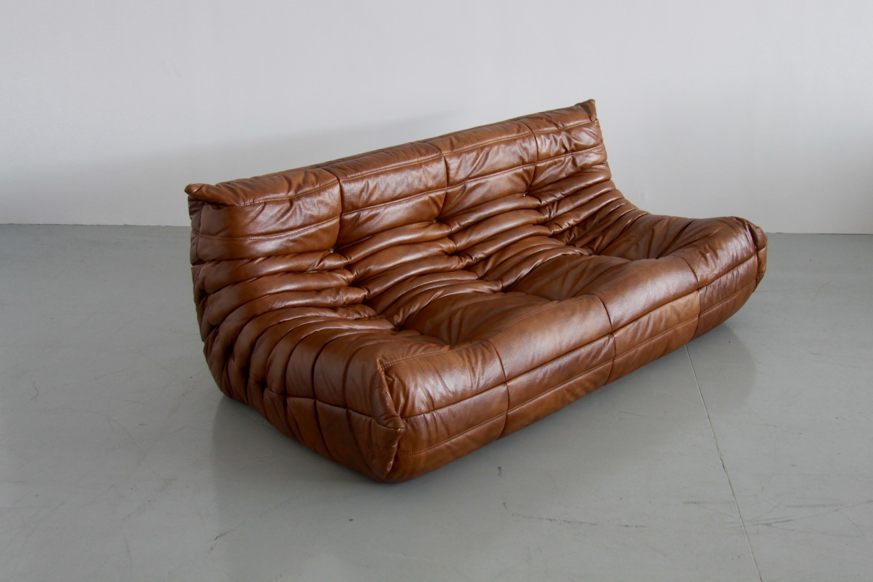 This Togo three-seat sofa was designed by Michel Ducaroy in the 1970s and was manufactured by Ligne Roset in France. It has been reupholstered in new whiskey leather (70 x 172 x 102 cm). It has the original Ligne Roset logo and genuine Ligne Roset