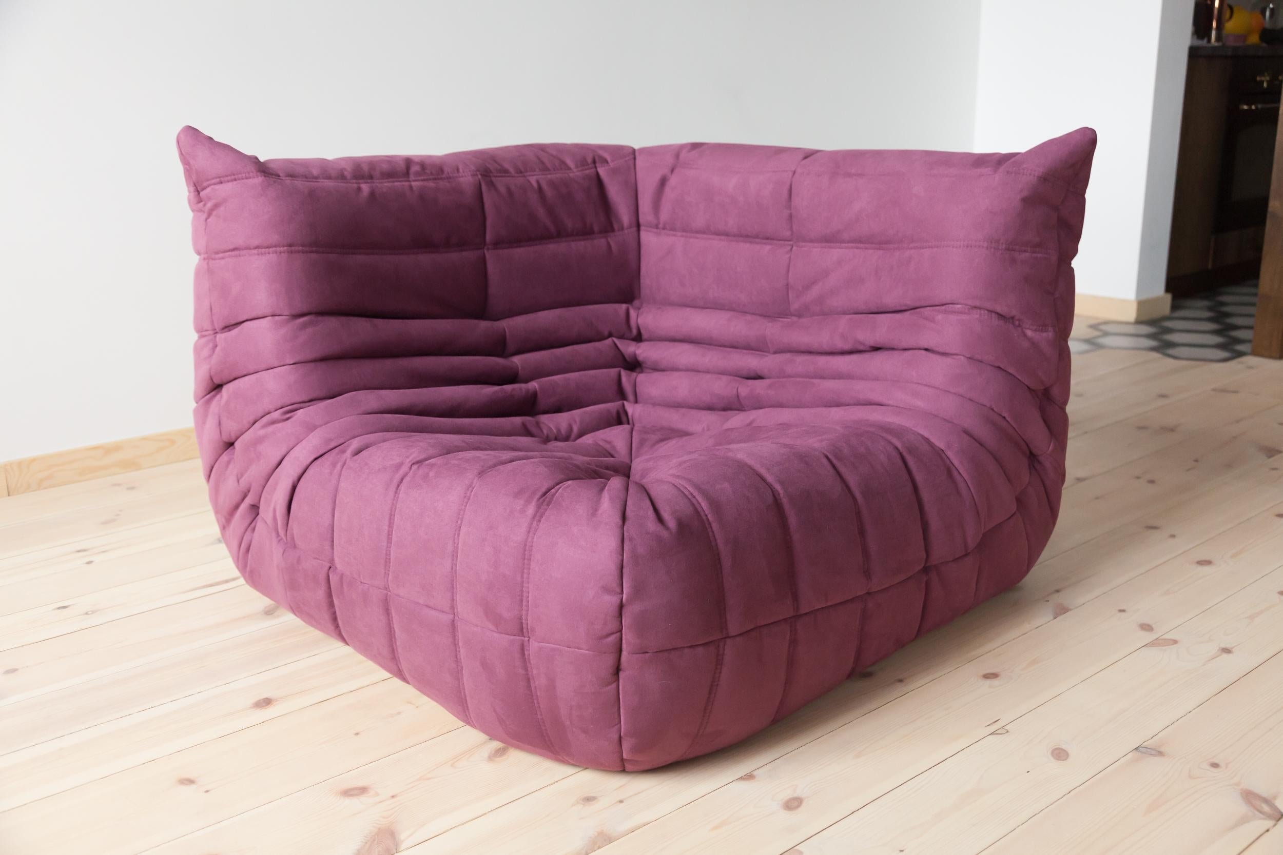 Diese Togo-Eckcouch wurde 1973 von Michel Ducaroy entworfen und von Ligne Roset in Frankreich hergestellt. Er wurde mit neuer aubergine/lila Mikrofaser bezogen (102 x 102 x 70 cm). Sie trägt das Original-Logo von Ligne Roset und einen echten Ligne