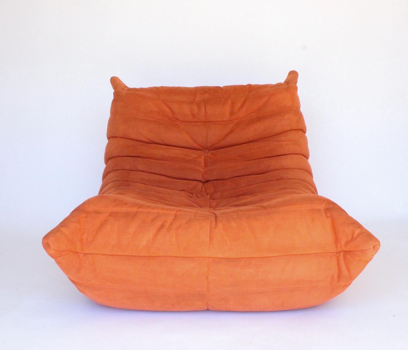 Iconic fireside Togo lounge chair was designed by Michel Ducaroy in 1973 for Ligne Roset, France. Togo Lounge Chair is Signed with Ligne Roset labels. This is a great example in the classic and highly desirable orange Ultra Suede Alcantara fabric,