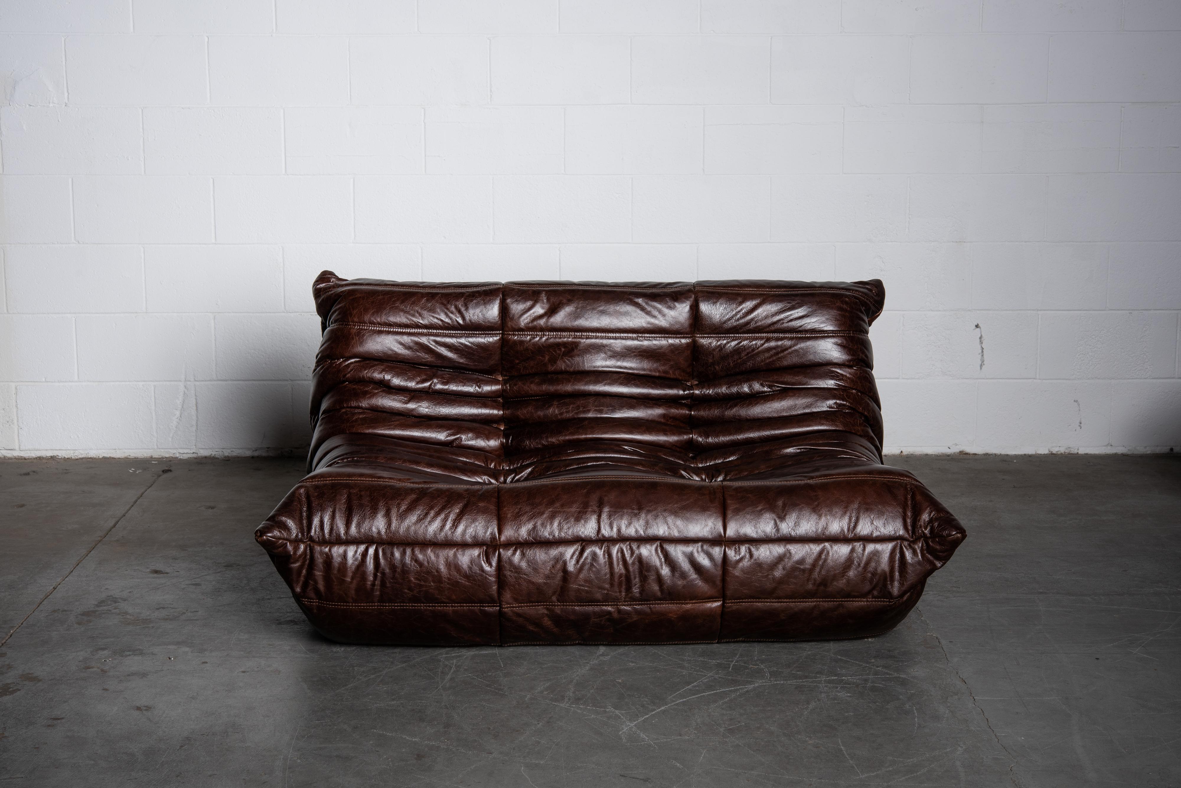 This incredible dark brown leather 'Togo' loveseat sofa was designed by Michel Ducaroy in 1973 for Ligne Roset, France. Signed with Ligne Roset label. Originally designed in the 1970s, this deep chocolate brown leather two-seater sofa was produced