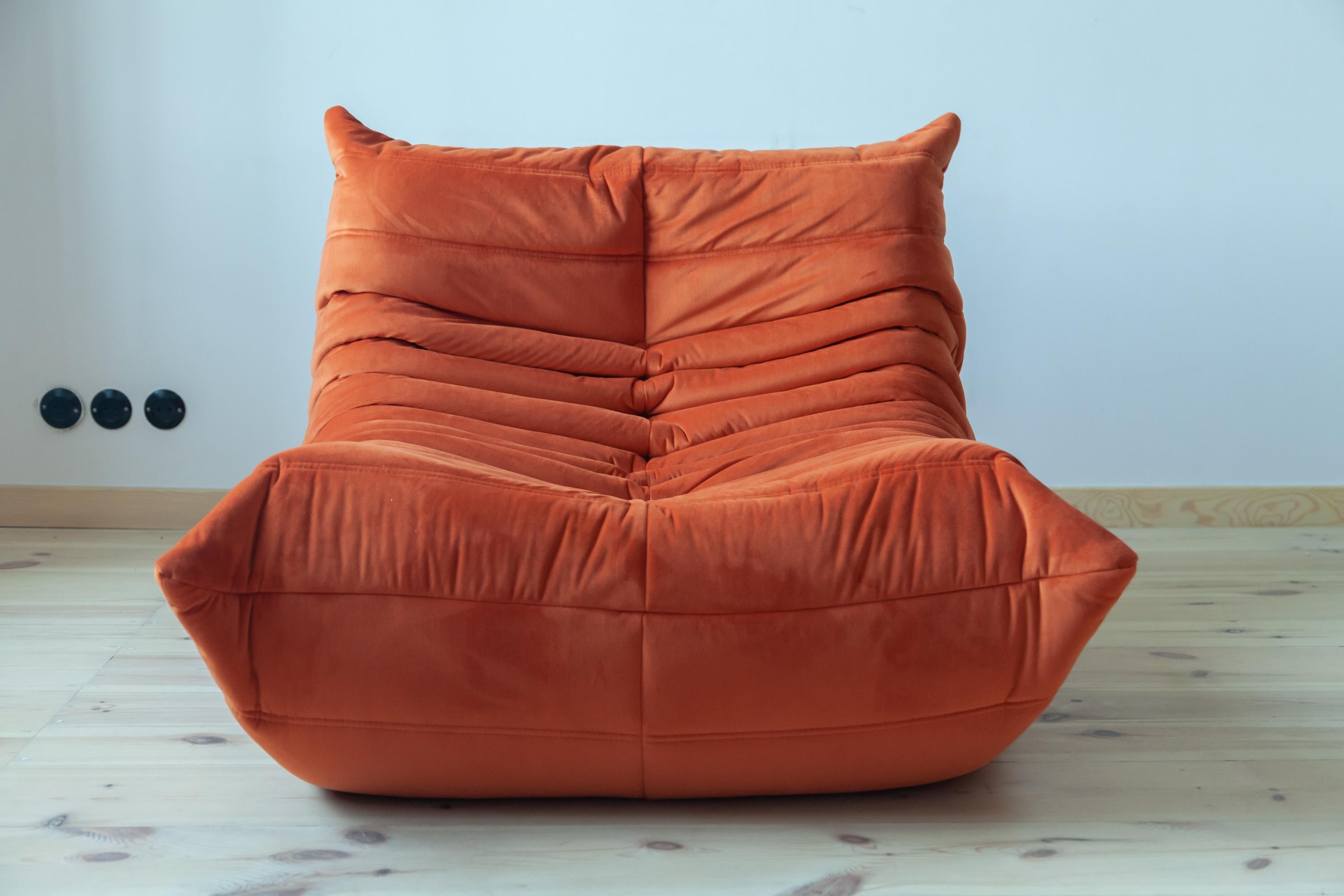 This Togo longue chair was designed by Michel Ducaroy in 1973 and was manufactured by Ligne Roset in France. It has been reupholstered in new orange velvet (70 x 87 x 102 cm). It has the original Ligne Roset logo and genuine Ligne Roset bottom.