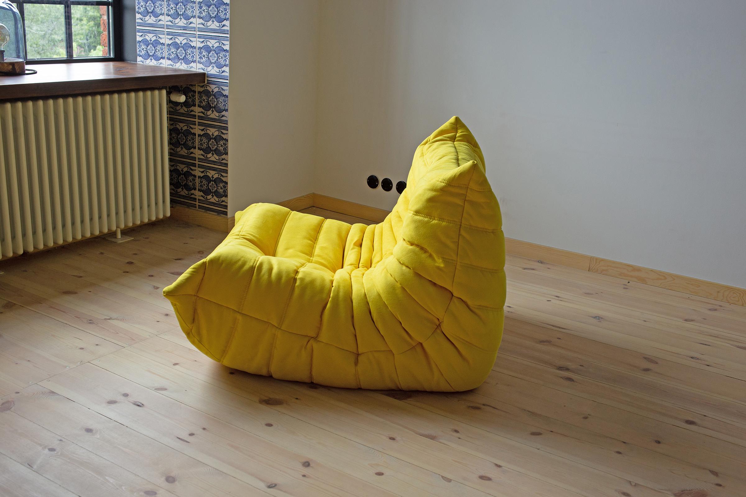 This Togo longue chair was designed by Michel Ducaroy in 1973 and was manufactured by Ligne Roset in France. It has been reupholstered in new yellow microfiber (87 x 102 x 70 cm). It has the original Ligne Roset logo and genuine Ligne Roset bottom.
