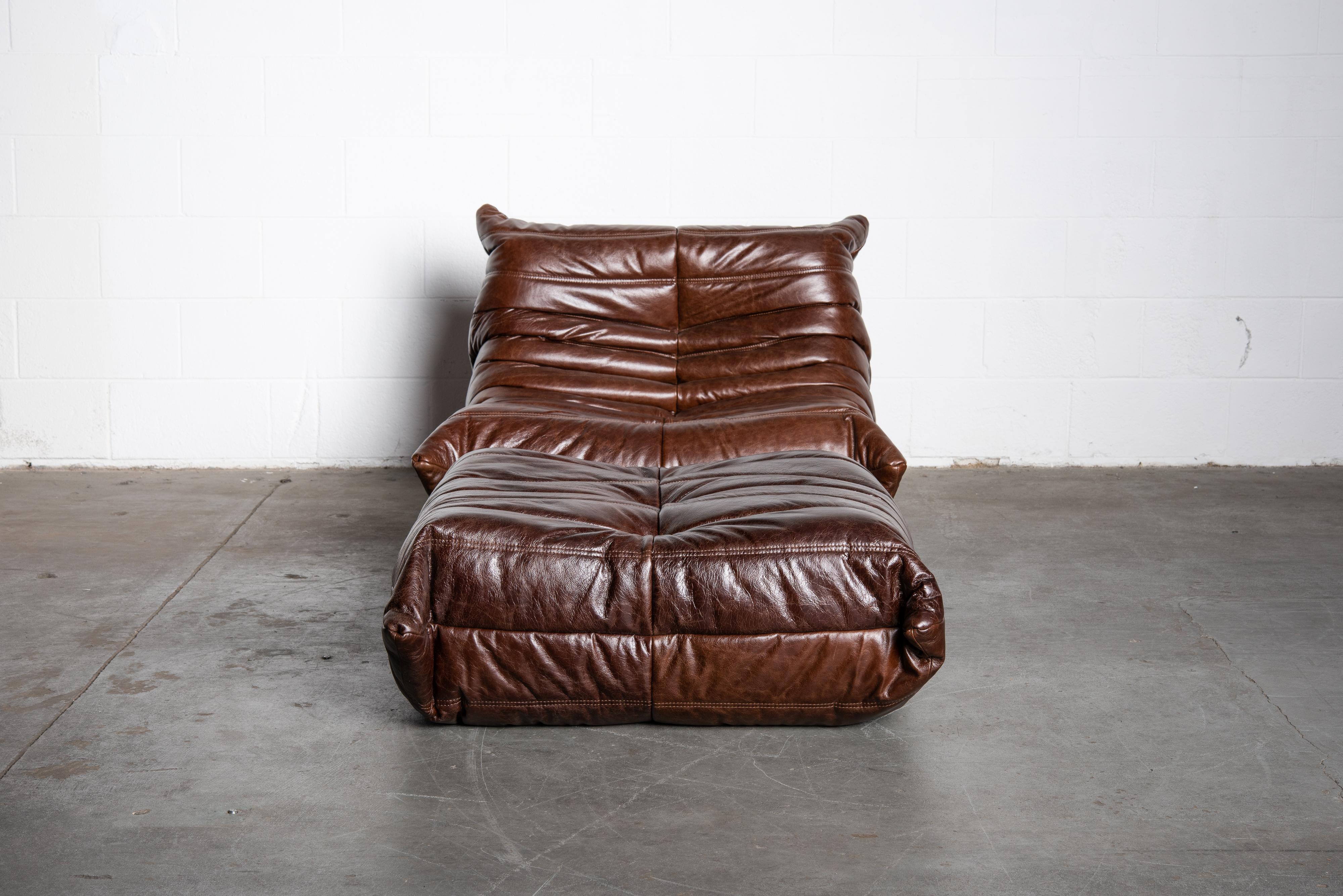 This incredible two piece 'Togo' fireside lounge chair and ottoman in dark brown leather was designed by Michel Ducaroy in 1973 for Ligne Roset, France. Signed with Ligne Roset underside decking fabric and labels on each piece. Originally designed