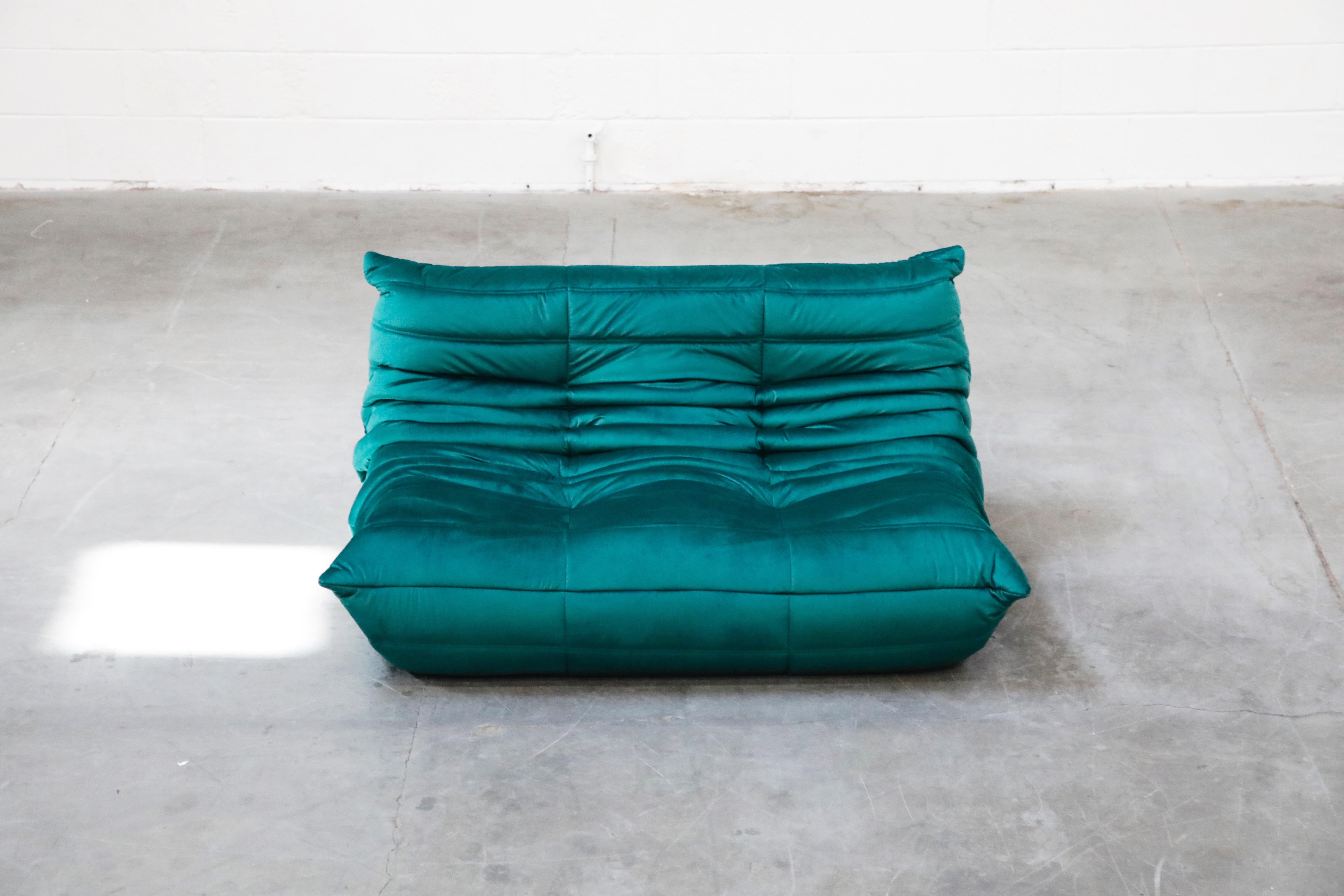 This incredible 'Togo' two-seat loveseat was designed by Michel Ducaroy in 1973 for Ligne Roset, France. This Togo loveseat sofa was completely restored with new high grade velvet upholstery in a mesmerizing Emerald Green color, and bottom decking