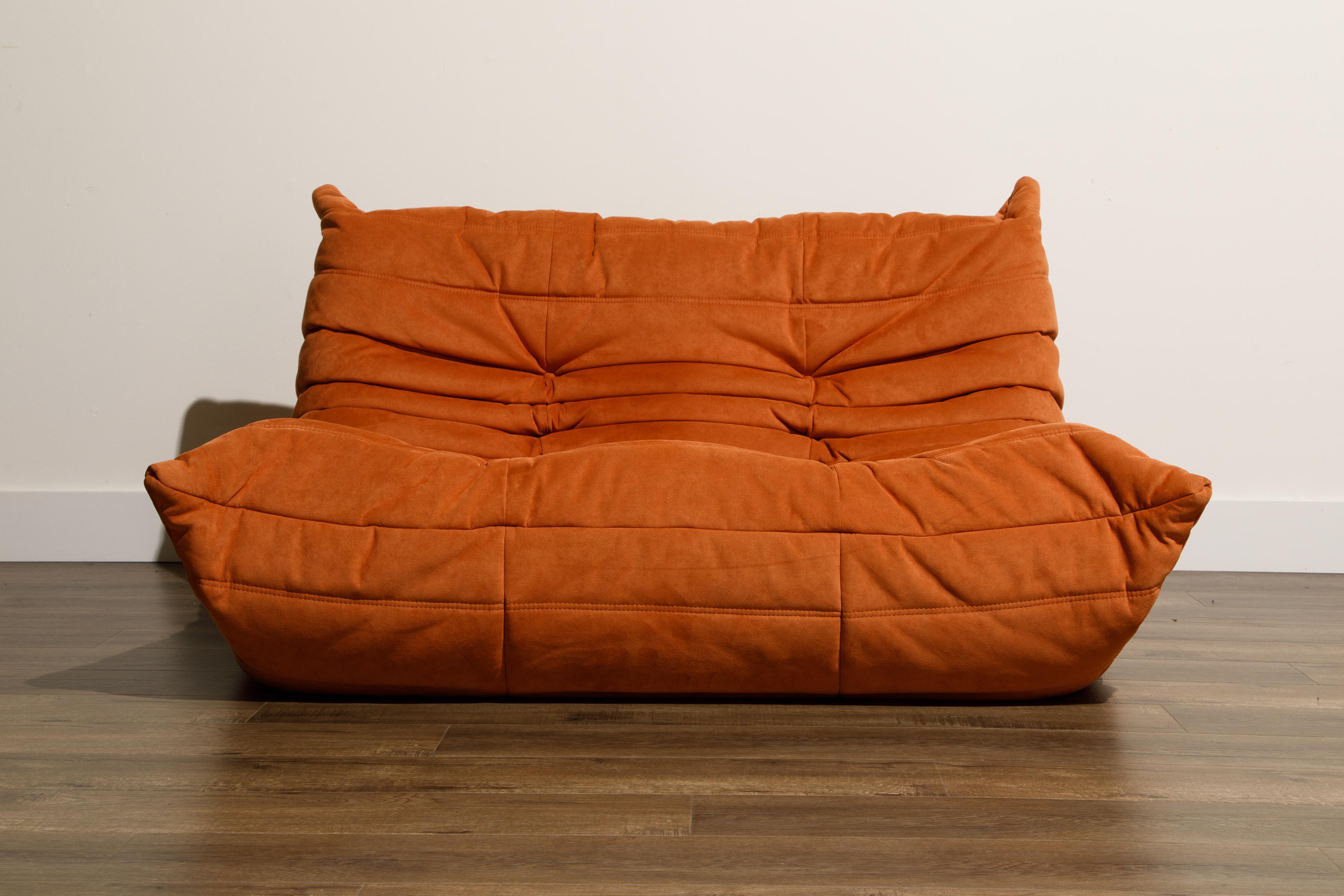 This incredible Togo loveseat sofa in orange alcantara was designed by Michel Ducaroy in 1973 for Ligne Roset, France. Signed with a Ligne Roset label. Timeless design make this Togo settee by Michel Ducaroy for Ligne Roset the perfect choice for