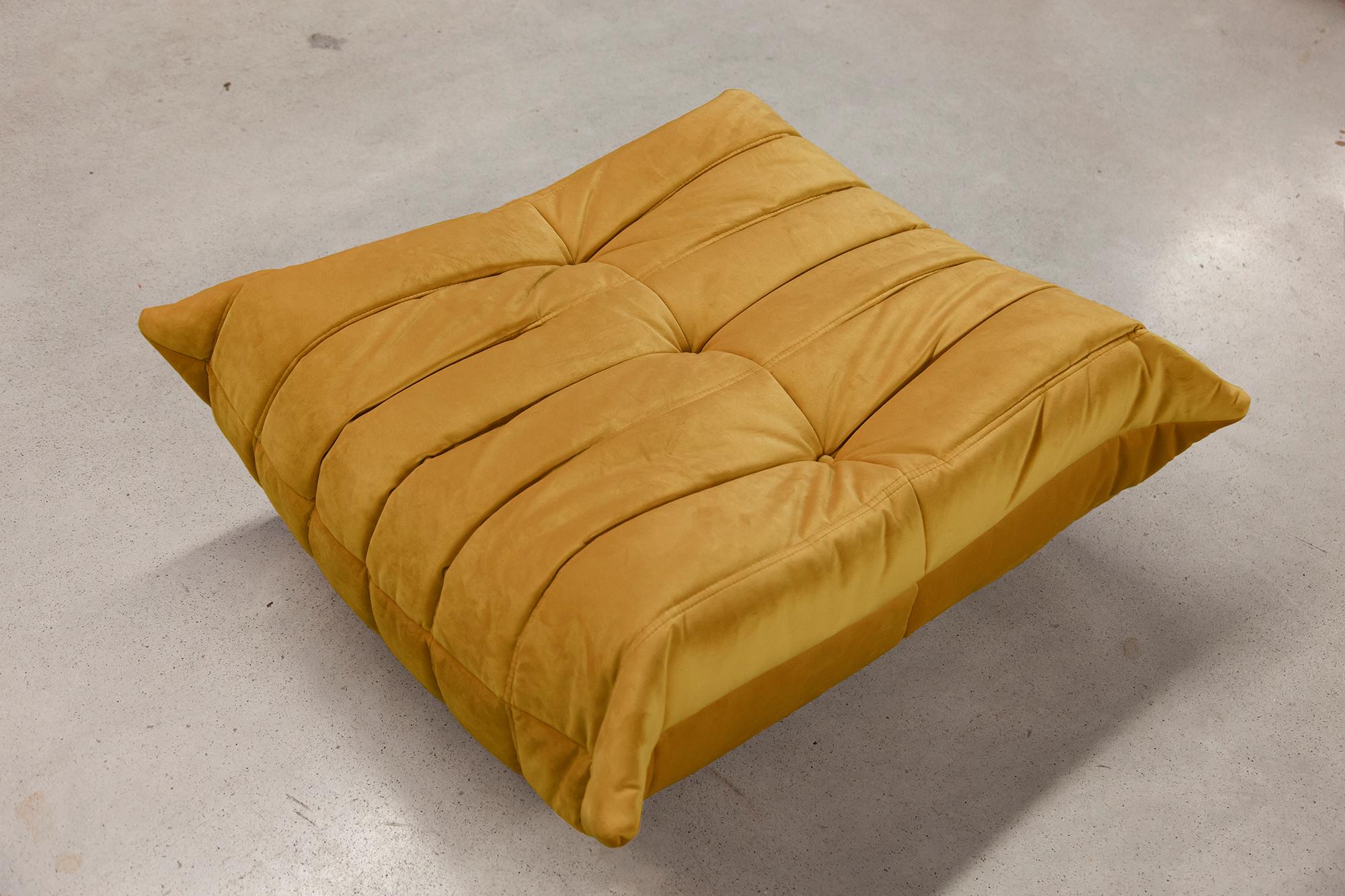 This Togo ottoman was designed by Michel Ducaroy in 1973 and was manufactured by Ligne Roset in France. It has been reupholstered in new golden yellow velvet (87 x 80 x 38 cm). It has the original Ligne Roset logo and genuine Ligne Roset bottom.