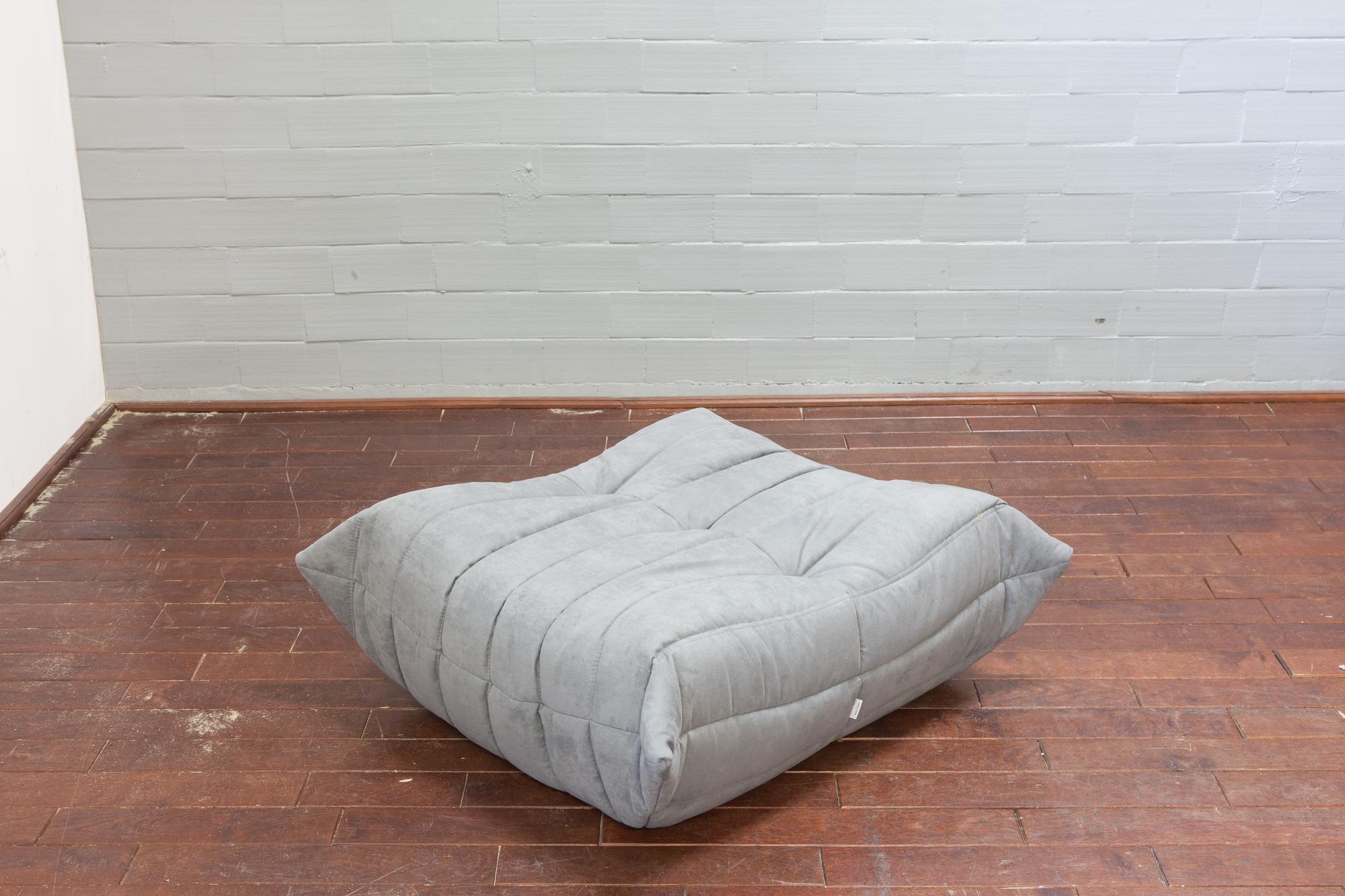 This Togo ottoman was designed by Michel Ducaroy in 1973 and was manufactured by Ligne Roset in France. It has been reupholstered in new light grey microfiber (87 x 80 x 34 cm). It has the original Ligne Roset logo and genuine Ligne Roset bottom.