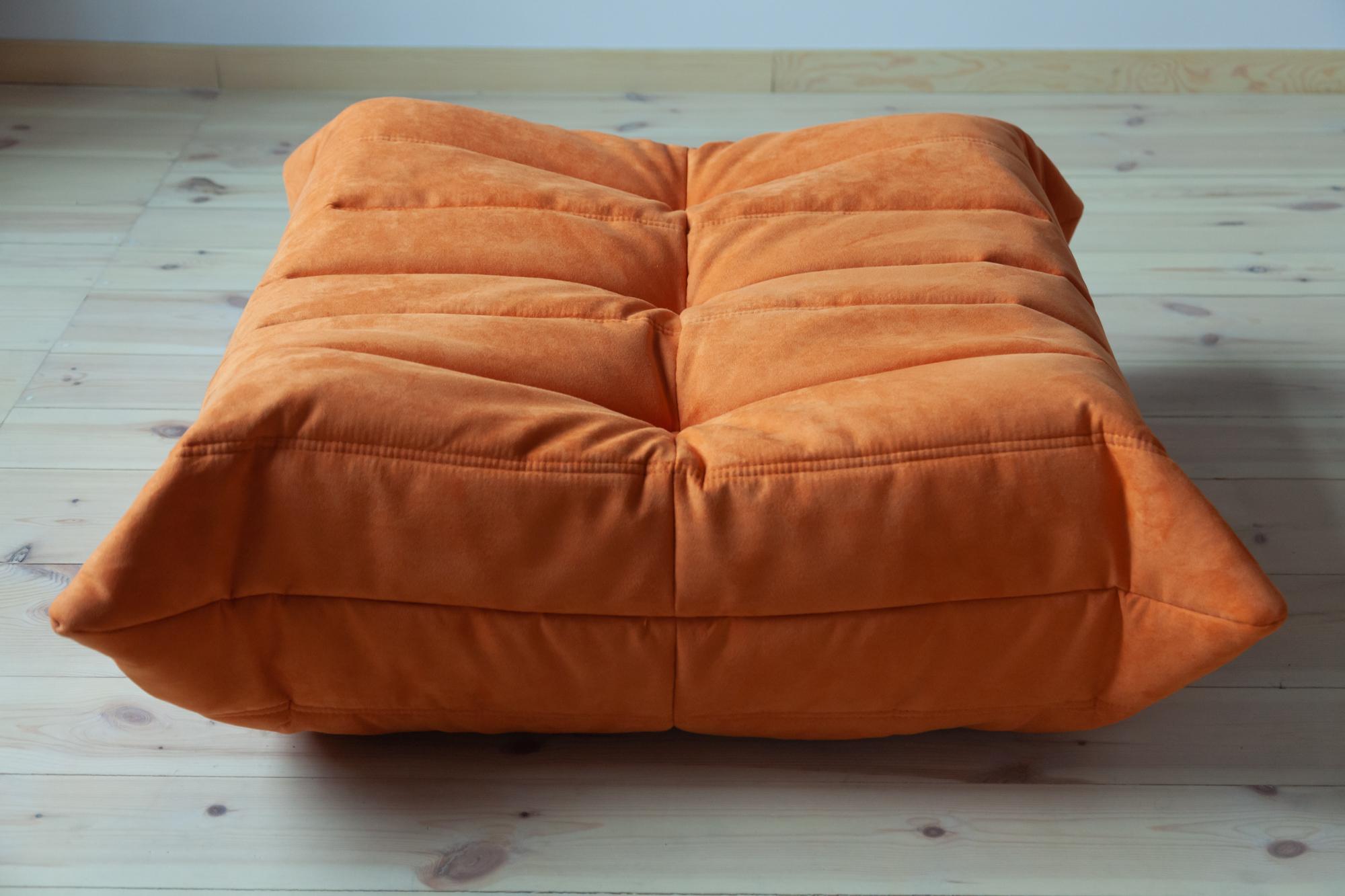 This Togo ottoman was designed by Michel Ducaroy in 1973 and was manufactured by Ligne Roset in France. It has been reupholstered in new orange microfibre (87 x 80 x 34 cm). It has the original Ligne Roset logo and genuine Ligne Roset bottom.