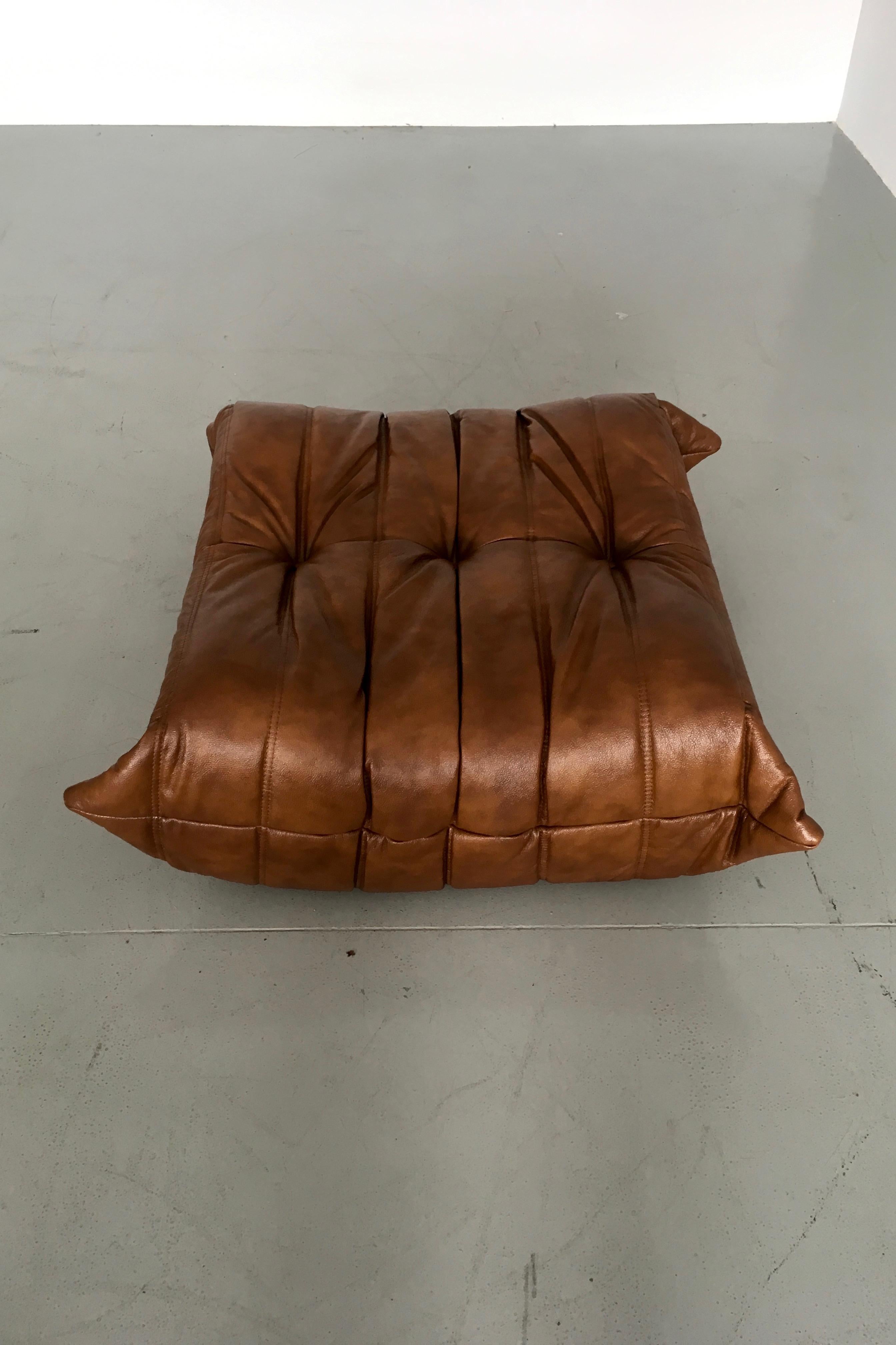 This Togo ottoman was designed by Michel Ducaroy in the 1973 and was manufactured by Ligne Roset in France, produced in 1990s. It has been reupholstered in new whiskey leather (87 x 80 x 34 cm). It has the original Ligne Roset logo and genuine Ligne