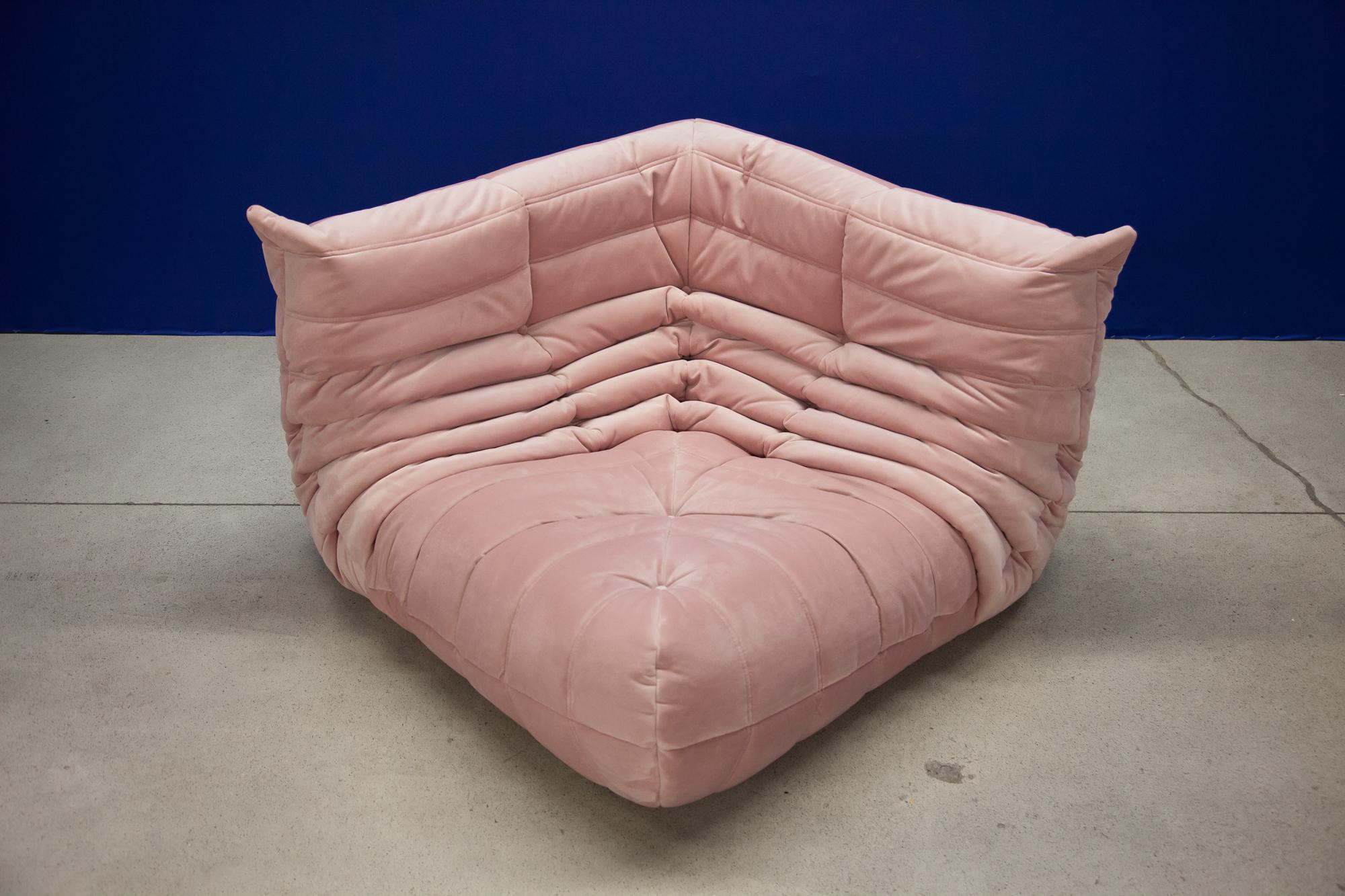 This Togo set including: 3-Seat, 2-seat and corner was designed by Michel Ducaroy in 1973 and was manufactured by Ligne Roset in France. It has been reupholstered in new pink velvet (70 x 174 x 102 cm). It has the original Ligne Roset logo and