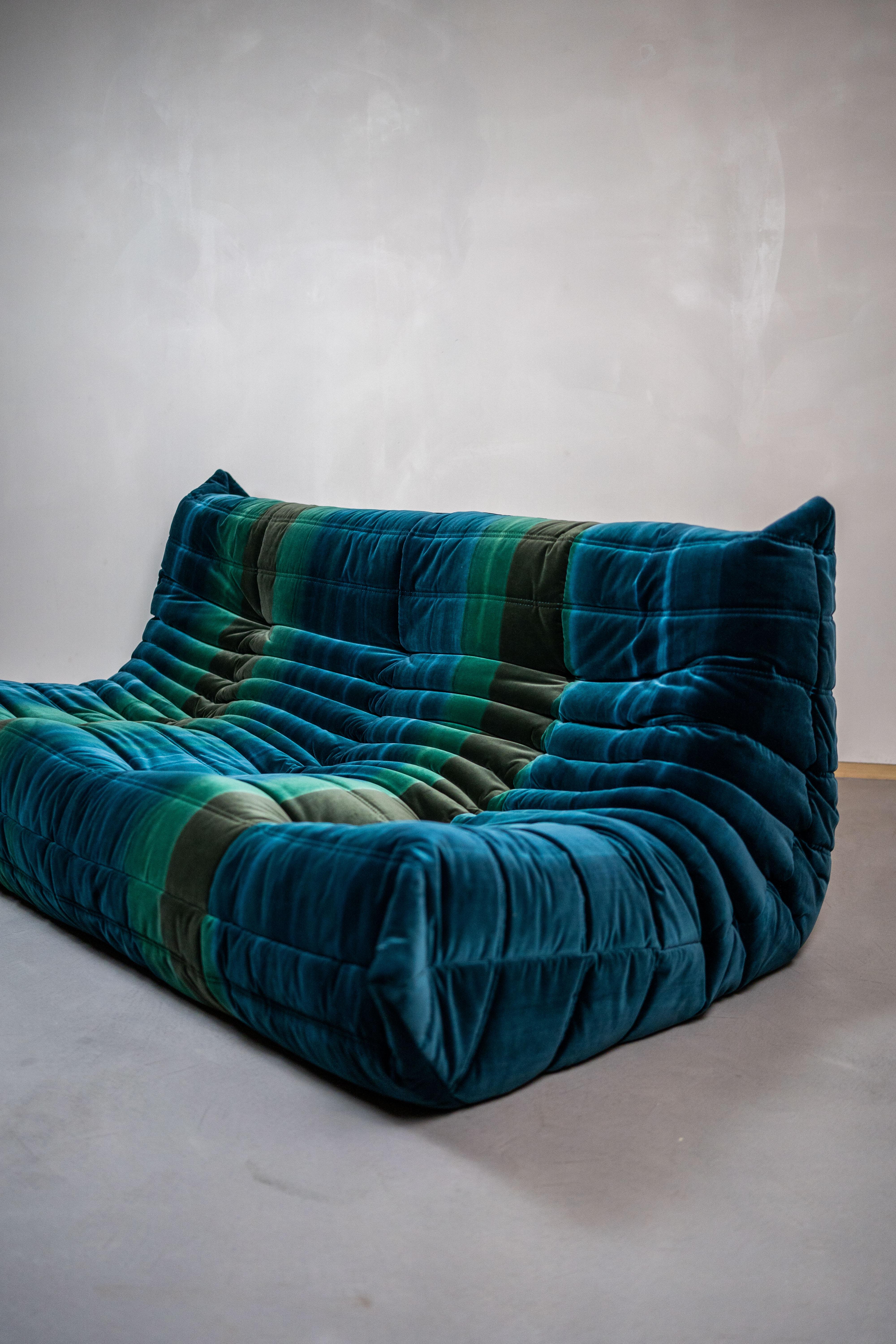 Togo sofa in velvet by Michel Ducaroy for Ligne Roset
The designer was inspired by the tooth paste tube
Three seater sofa, upholstered in soft and smooth vetvet. The colour and and patern are unique. It is green, blue and turquiase stripes. 
The