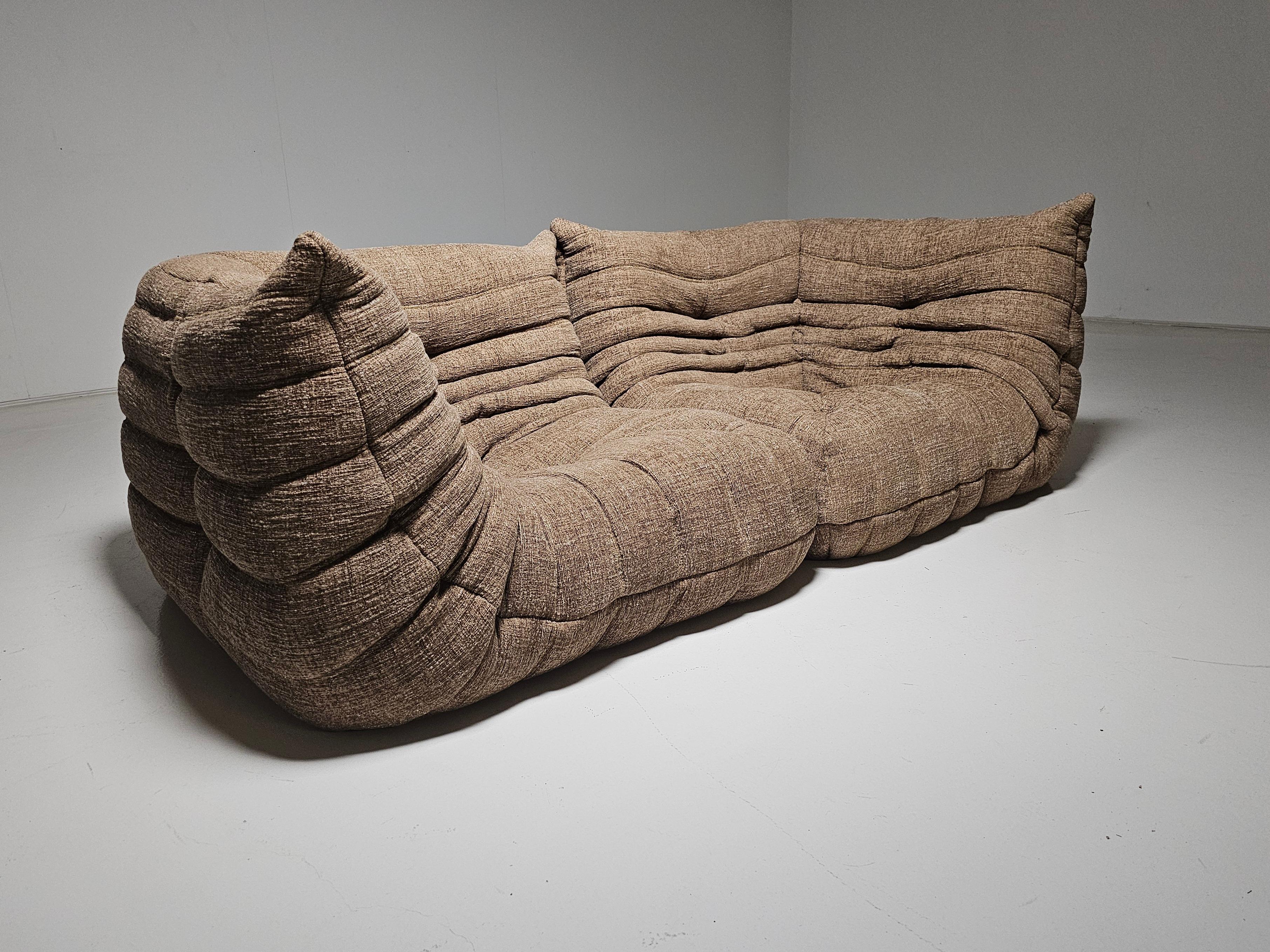 Togo sofa/lounge chairs designed by Michel Ducaroy in the 1970s for Ligne Roset.
It shows a nice warm natural color tone and its famous wrinkled cozy design.
Lined underneath with original fabric. Reupholstered in a high-quality textured fabric by