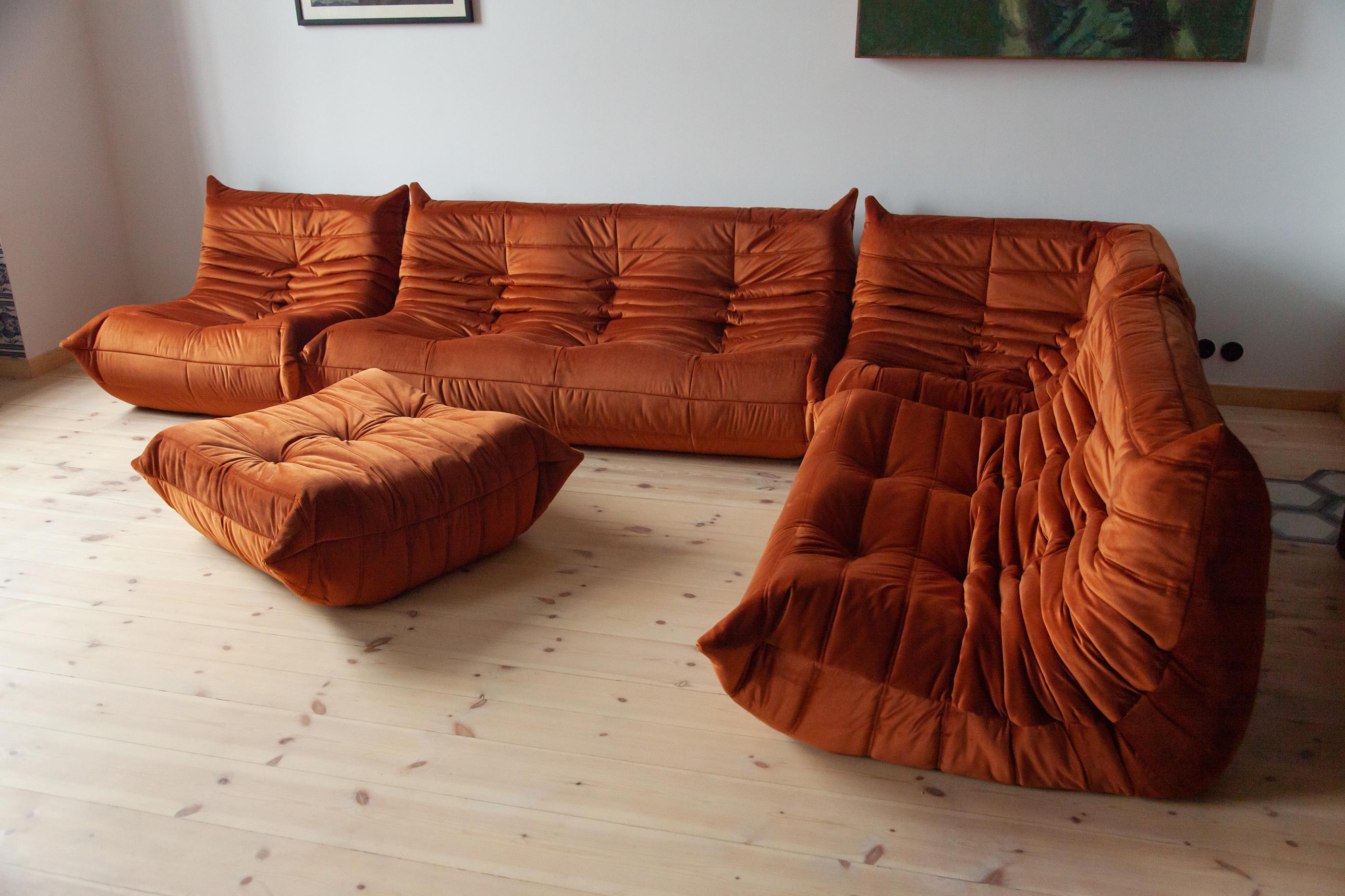 This Togo living room set was designed by Michel Ducaroy in 1973 and was manufactured by Ligne Roset in France. It has been reupholstered in new, great quality amber velvet and is made up of the following pieces: One three-seat couch (70 x 174 x 102