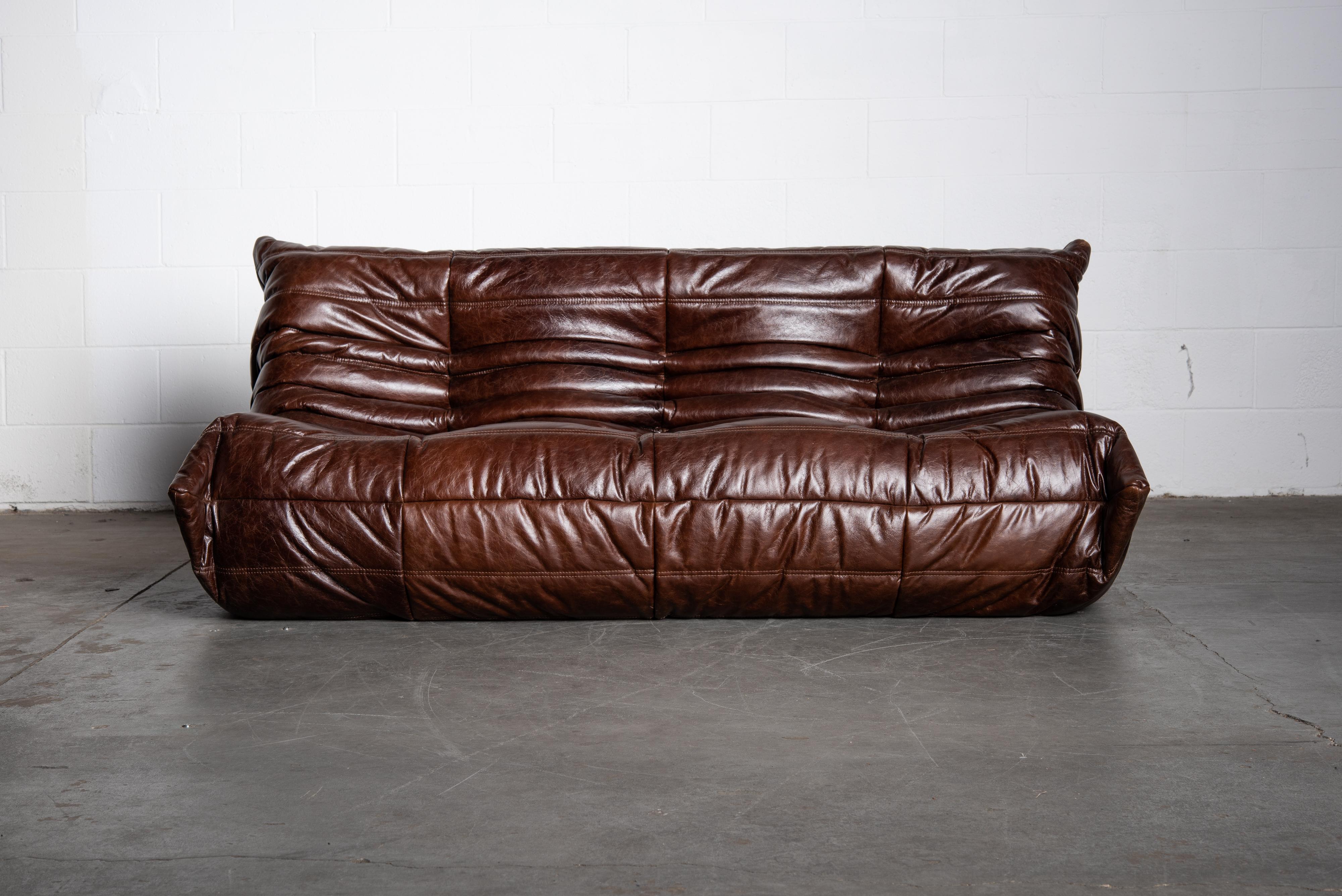 This incredible dark brown leather 'Togo' three-seat sofa was designed by Michel Ducaroy in 1973 for Ligne Roset, France. Signed with Ligne Roset underside decking fabric and label. Originally designed in the 1970s, this deep chocolate brown leather