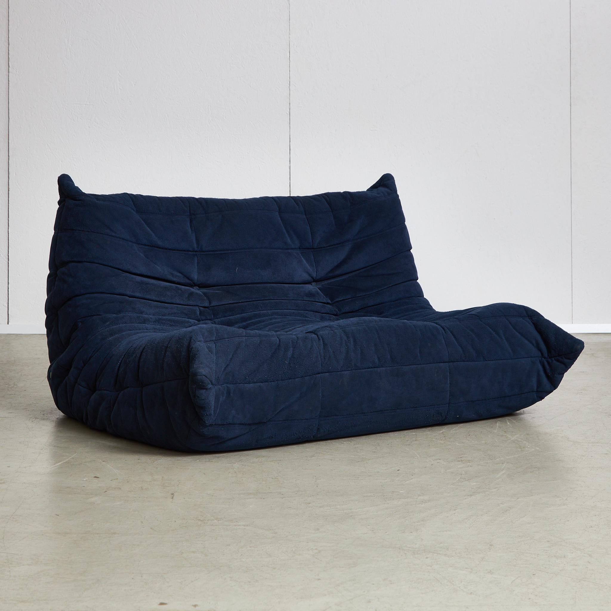 The Togo Two-Seater Sofa, designed by Michel Ducaroy for Ligne Roset in 1973, is an iconic piece of furniture that represents the innovative design trends of the late 20th century. Its unique, low-profile silhouette and distinctive, soft forms are