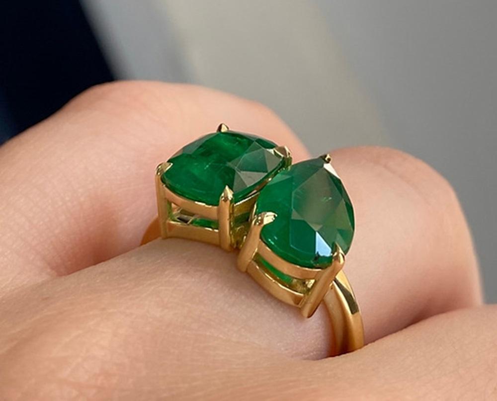 Emerald Weight: 5.26 CTS (Pear 2.62 CTS + Cushion 2.64 CTS), Emerald Measurements: 11.77 x 7.93/9.54 x 8.55 mm, Metal: 18K Yellow Gold, Ring Size: 7, Shape: Pear/Cushion, Color: Green, Hardness: 7.5-8, Birthstone: May
