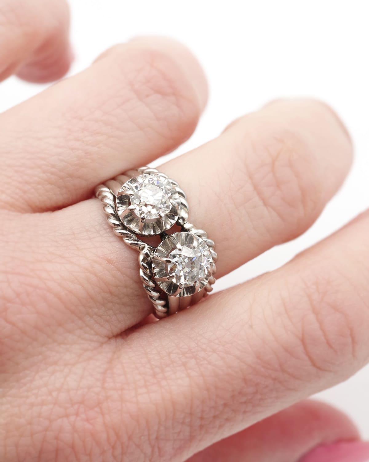 Anello con diamante Toi & Moi in platino. Anello anni '50 centrato da due diamanti taglio vecchio di 0,60 ct e 0,70 ct. I due diamanti sono incorniciati da un motivo attorcigliato che imita una corda. La fascia è ornata da tre ceselli. Anello degli
