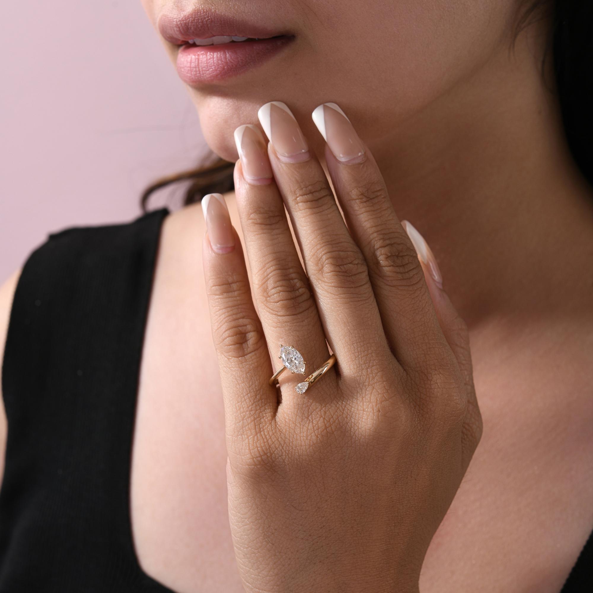 Toi et Moi Bague ouverte en or jaune 18 carats avec diamant marquise et poire Bijoux fins
Cette bague contemporaine présente une superbe pierre centrale taillée en marquise associée à une délicate pierre d'accent taillée en poire, le tout monté sur