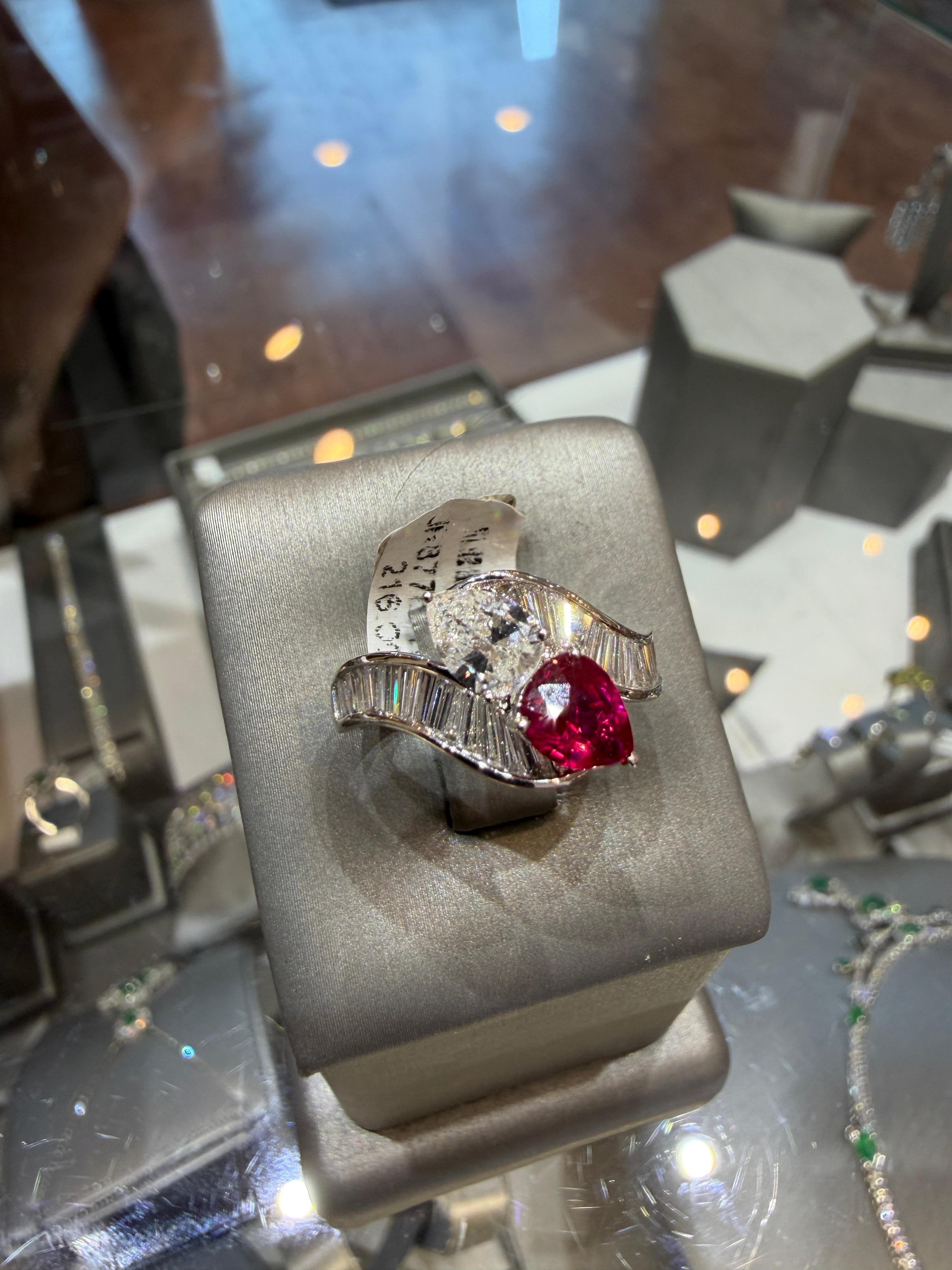 Un sorprendente e romantico anello di alta gioielleria Toi et Moi, magistralmente realizzato in oro bianco 18 carati e che mette in mostra un raro rubino del Mozambico senza calore abbinato a un diamante a forma di pera eccezionalmente luminoso.