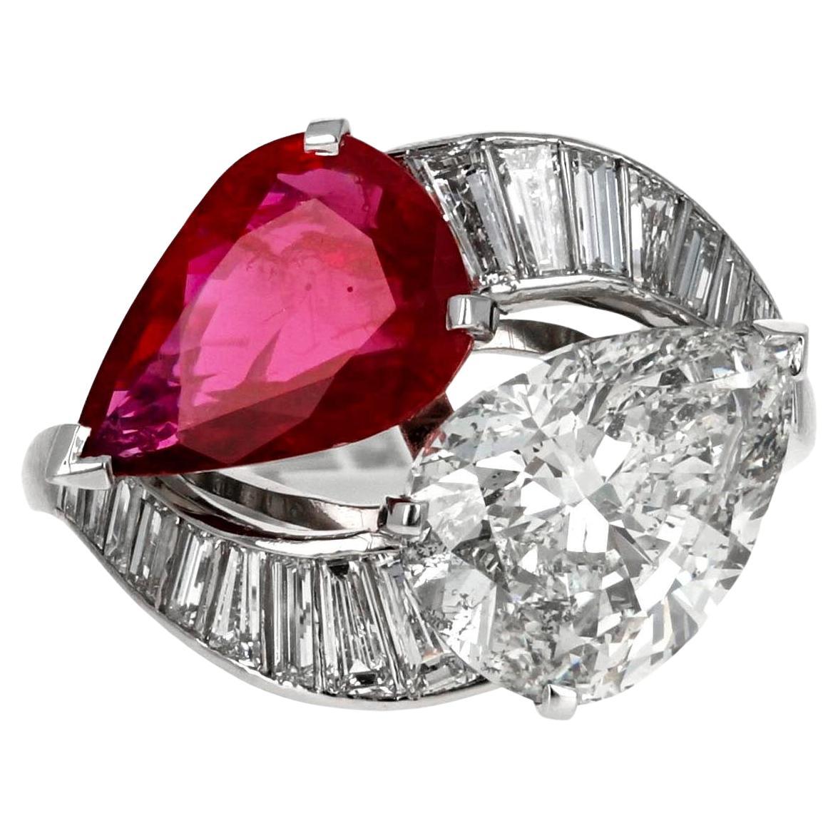 Dieser Platinring zeigt eine atemberaubende Kombination aus einem großen birnenförmigen, GIA-zertifizierten Diamanten und einem birnenförmigen Rubin, die das Design Toi et Moi oder Bypass bilden.  Der GIA-zertifizierte birnenförmige Diamant wiegt