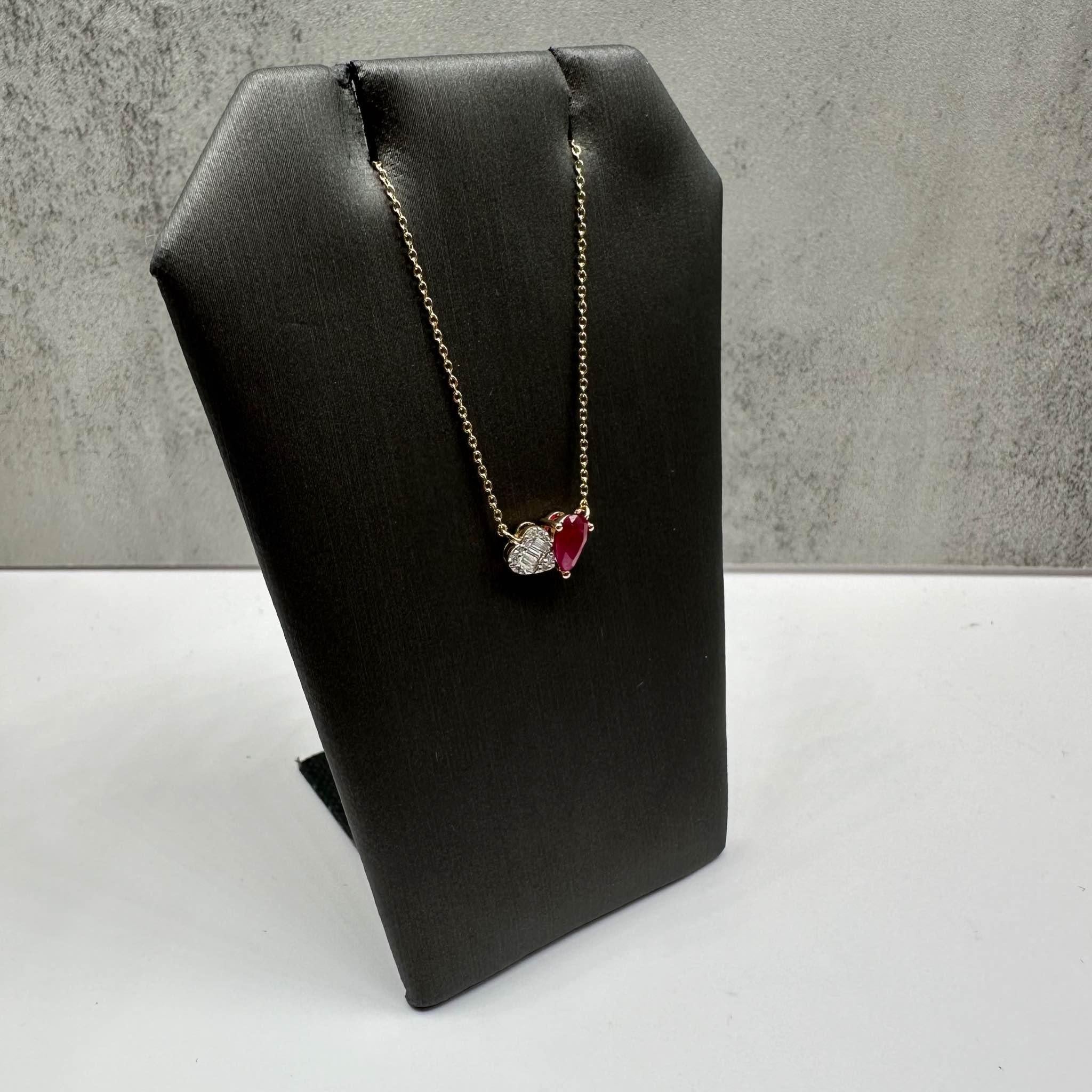 Cet élégant collier rubis et diamants Toi Et Moi Style en or jaune 14kt présente 0,15ctw de diamants ronds et baguettes GH SI naturels, joliment associés à un rubis poire de 0,50ctw pour un contraste saisissant de couleur et d'éclat. Le collier