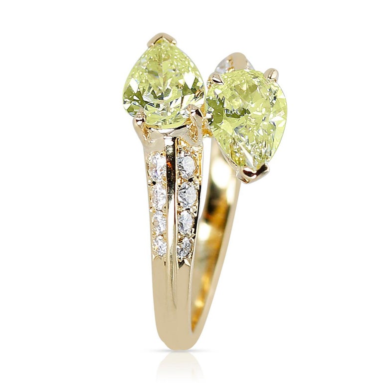  A Toi Et Moi Yellow Diamond Double Pear-Shape Ring with White Round Diamonds made in 18 Karat Yellow Gold. 
The two diamonds weigh 1.23 carats total. The white round diamonds weigh 0.26 carats. The total weight of the ring is 3.15 grams. The ring