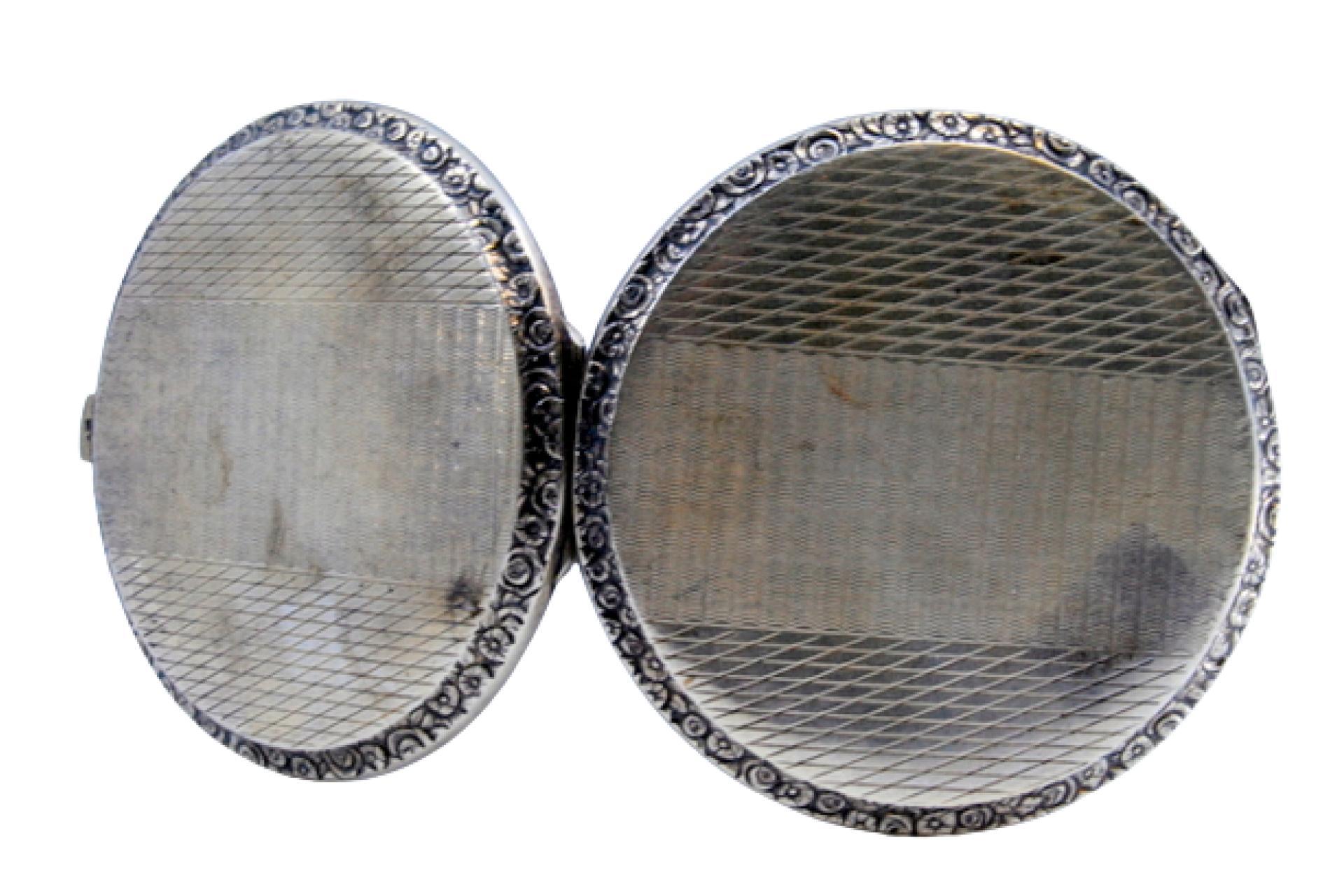 Description: Silver toiletry box with guilloche design on both sides and a mirror inside. Metal: Silver. Origin: Portuguese. Brand: Cabeça de escravo. Weight: 84.91 grams. Dimensions: 8x0.8cm. Content: 833/1000. Assay Mark: Yes, between 1938 and