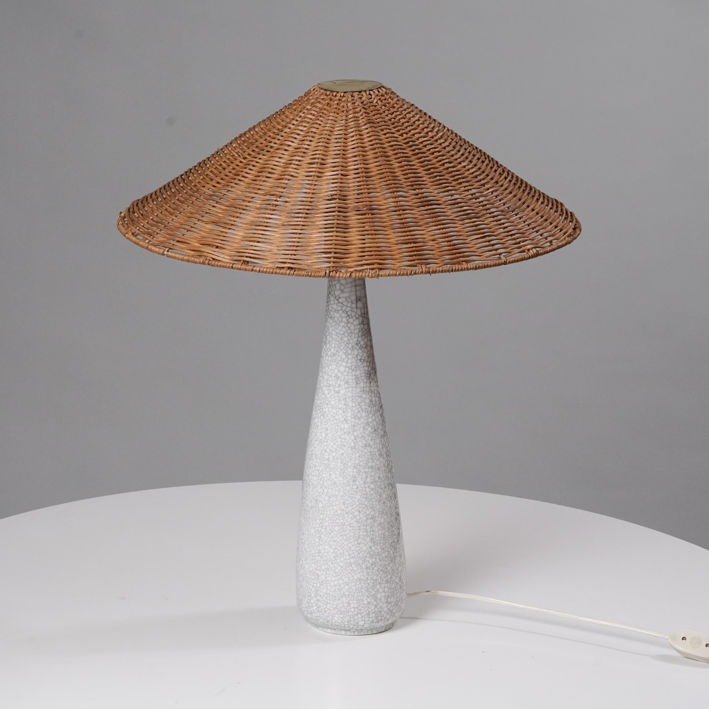 Lampe de table en céramique émaillée Toini Muona, fabriquée par Arabia, années 1950. Abat-jour en osier, détails en laiton. Marqué. Bon état vintage, patine mineure correspondant à l'âge et à l'utilisation. 

Toini Muona était un pionnier du