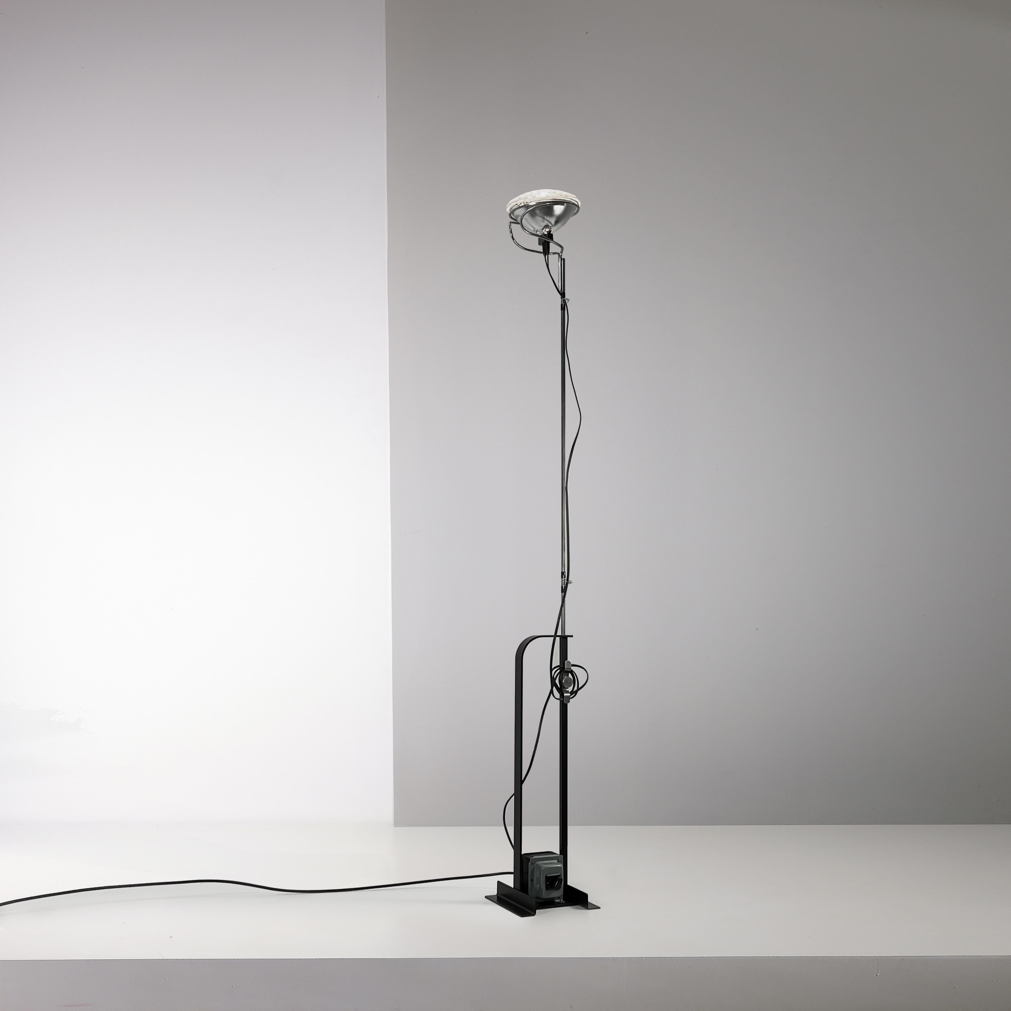 This matte black Toio lamp designed by Achille Castiglioni for Flos is a rare First Edition from 1962

The lamp exhibits a splendid patina throughout all its parts. Every component is operational, including the transformer.