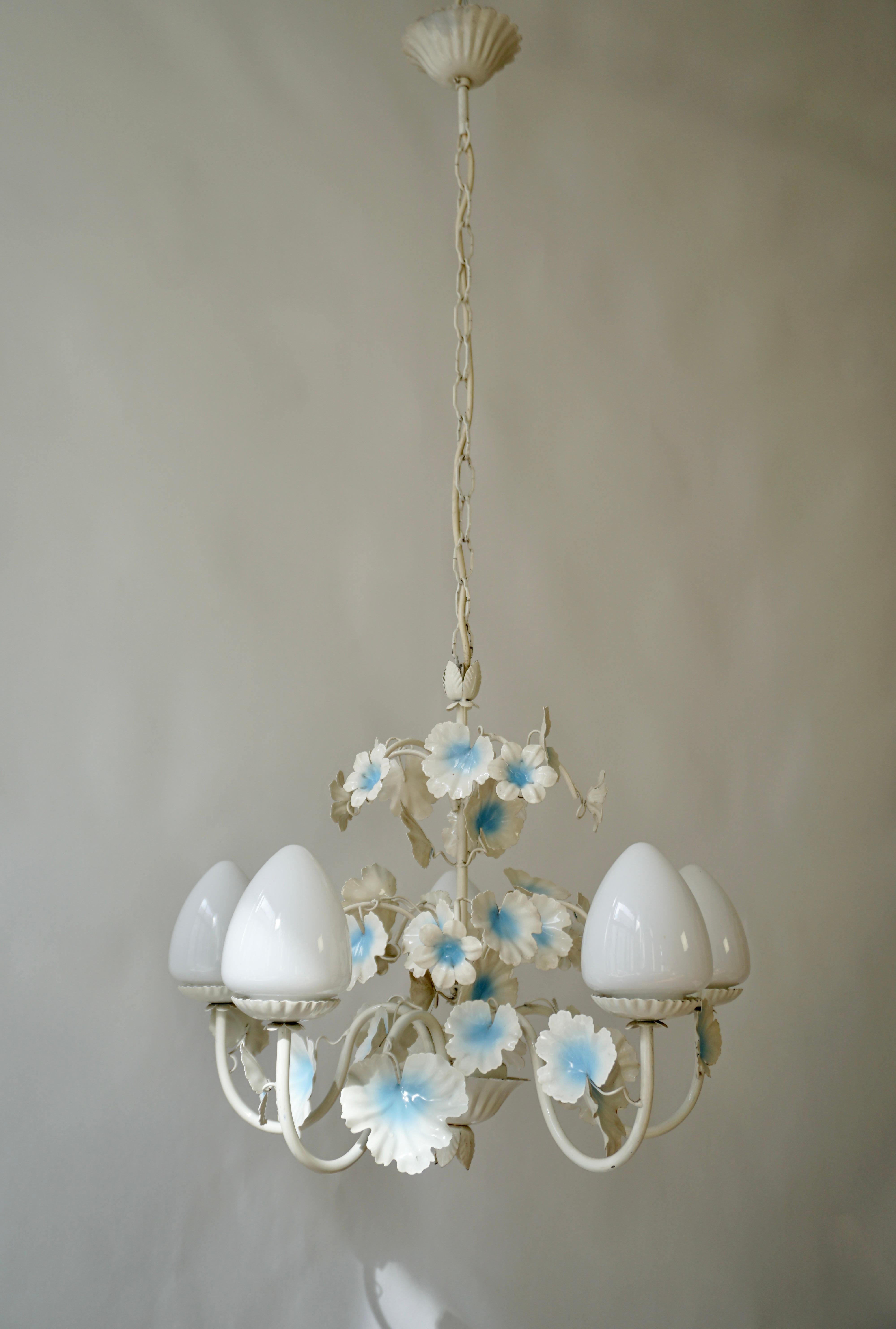 Lampadario italiano a tole con cinque globi di vetro opalino e foglie bianche e azzurre.

La lampada richiede cinque lampadine singole a vite E14 (40Watt max.) compatibili con i LED.

Diametro 52 cm.
Altezza apparecchio 45 cm.
Altezza totale 105 cm.
