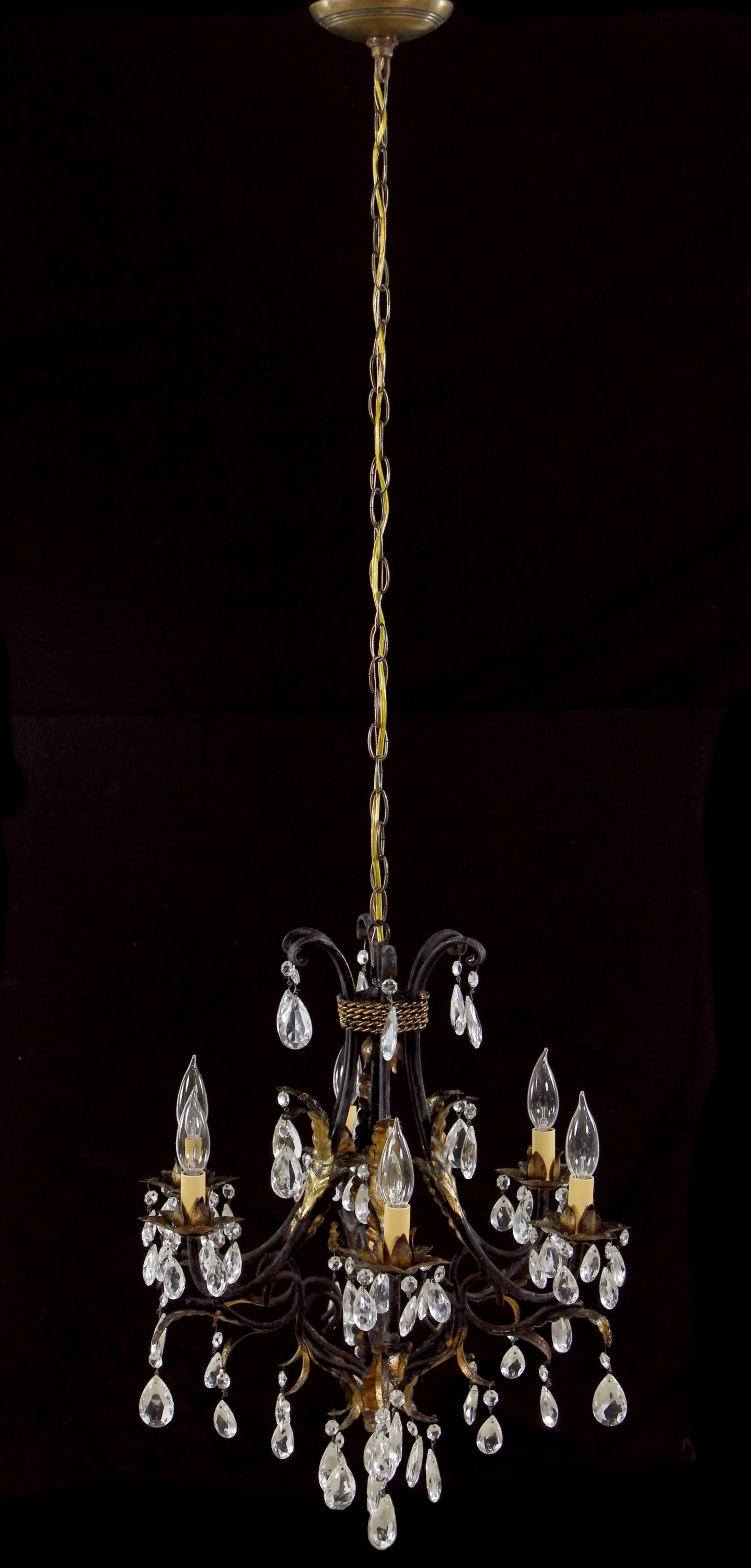 Early 20th Century Tole chandelier. Featuring black finish with gold gilt leaves and vines and ropes details. Six arms dripping with crystals. Cleaned and rewired. Please note, this item is located in our Los Angeles location.