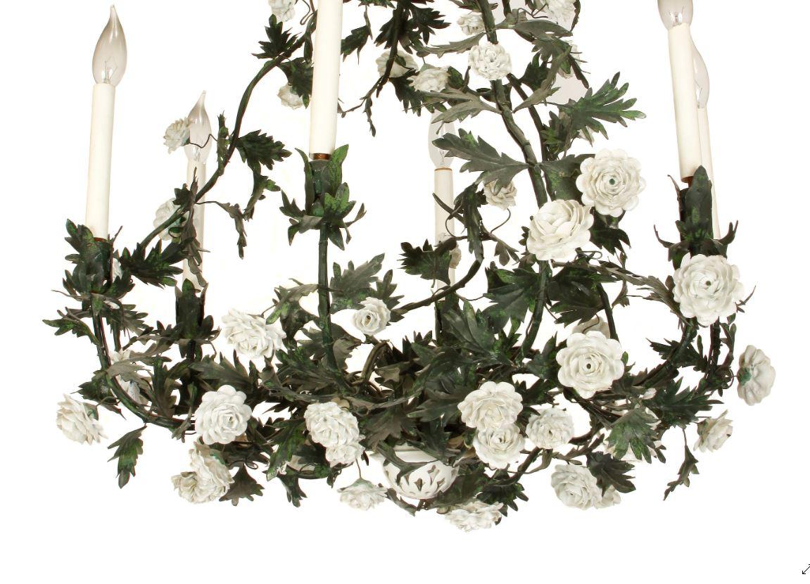 Tole floral, leaf and vine chandelier in round shape. White porcelain flowers surround the green leaves and vines with white candle lights