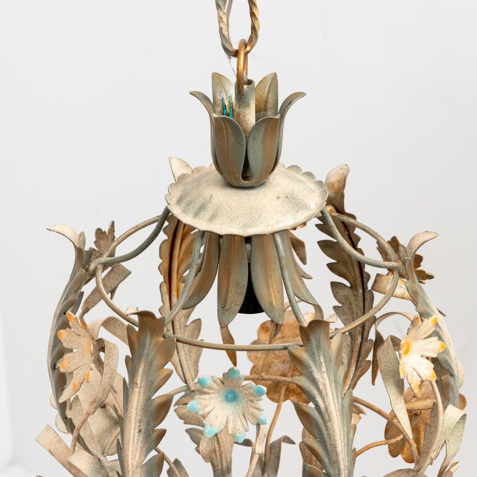Circa 1970s petite painted Tole floral chandelier in the Hollywood Regency style with single bulb. The chandelier measures 12.00 inches long without the attached chain, original ceiling cap included. Please note of wear consistent with age. New
