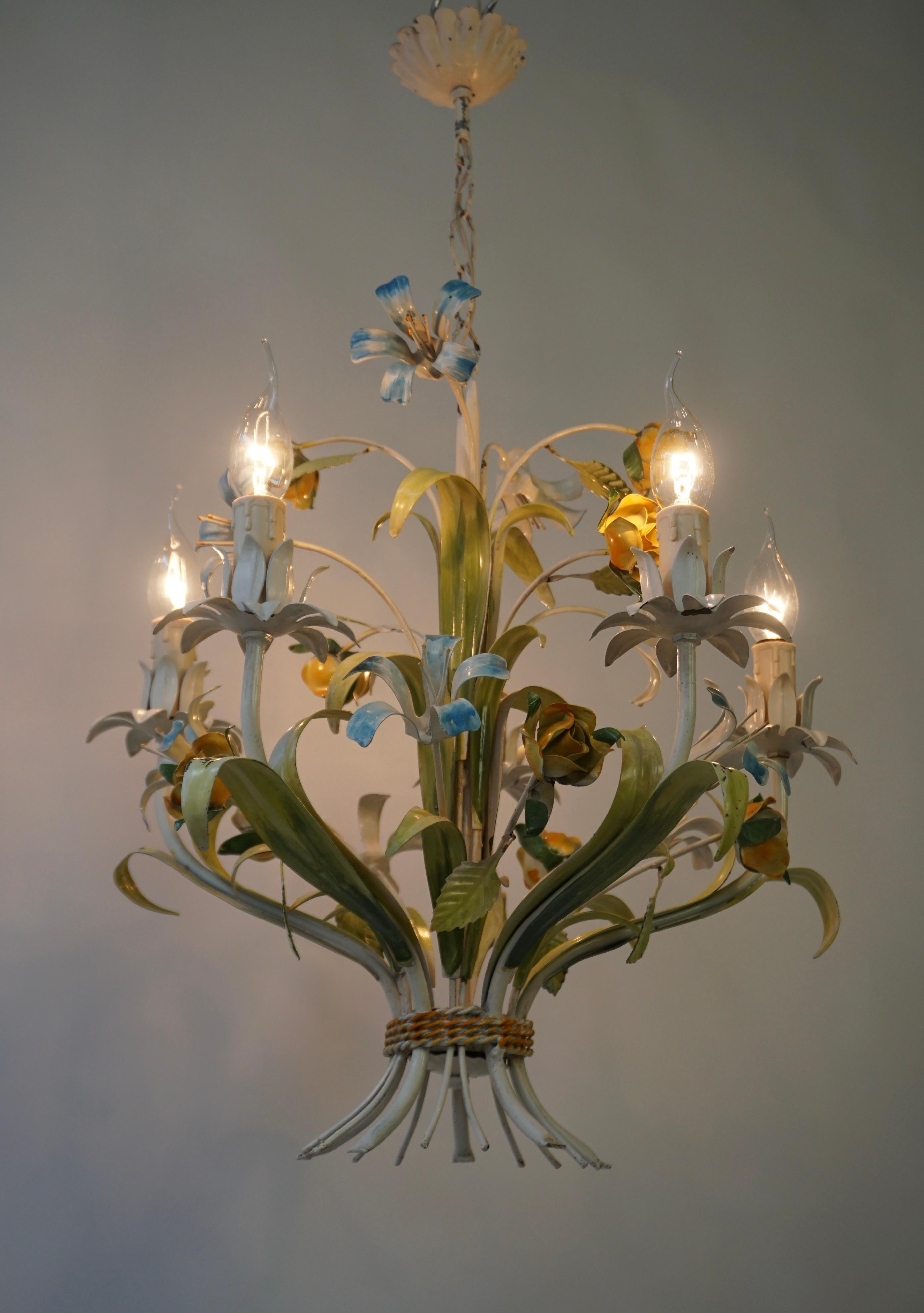 Vintage 1950s hanging lamp from Italy with striking colors, made in the shape of a bouquet of lilies and roses.
The lamp has five light points and has a warm, attractive and romantic appearance.

A  Hollywood Regency tole five-armed pendant light